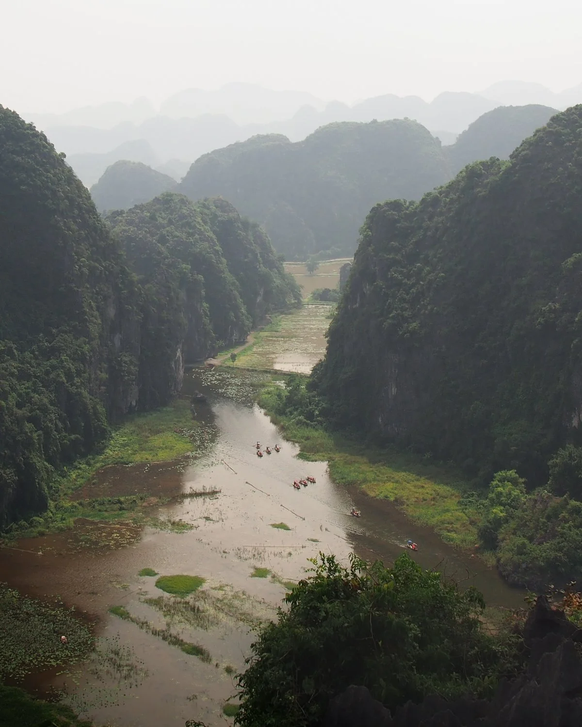 A scenic view down to a valley with a river flowing through it.