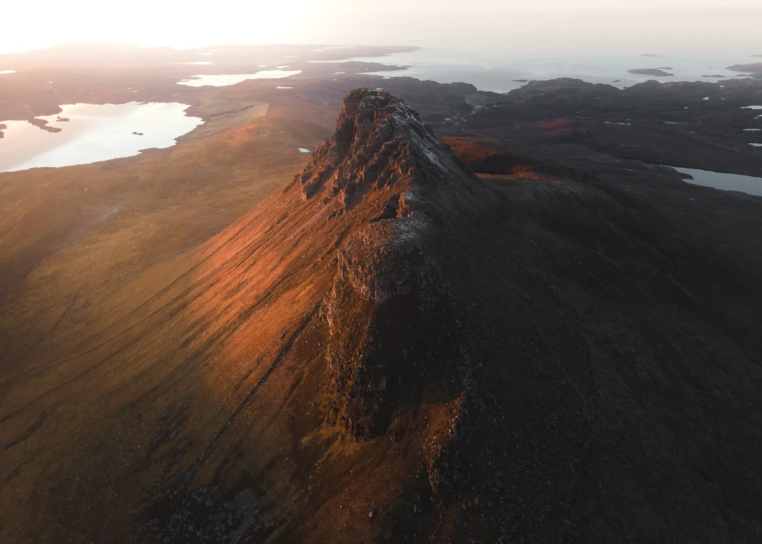 A dramatic aerial view of Stac Pollaidh at sunset.