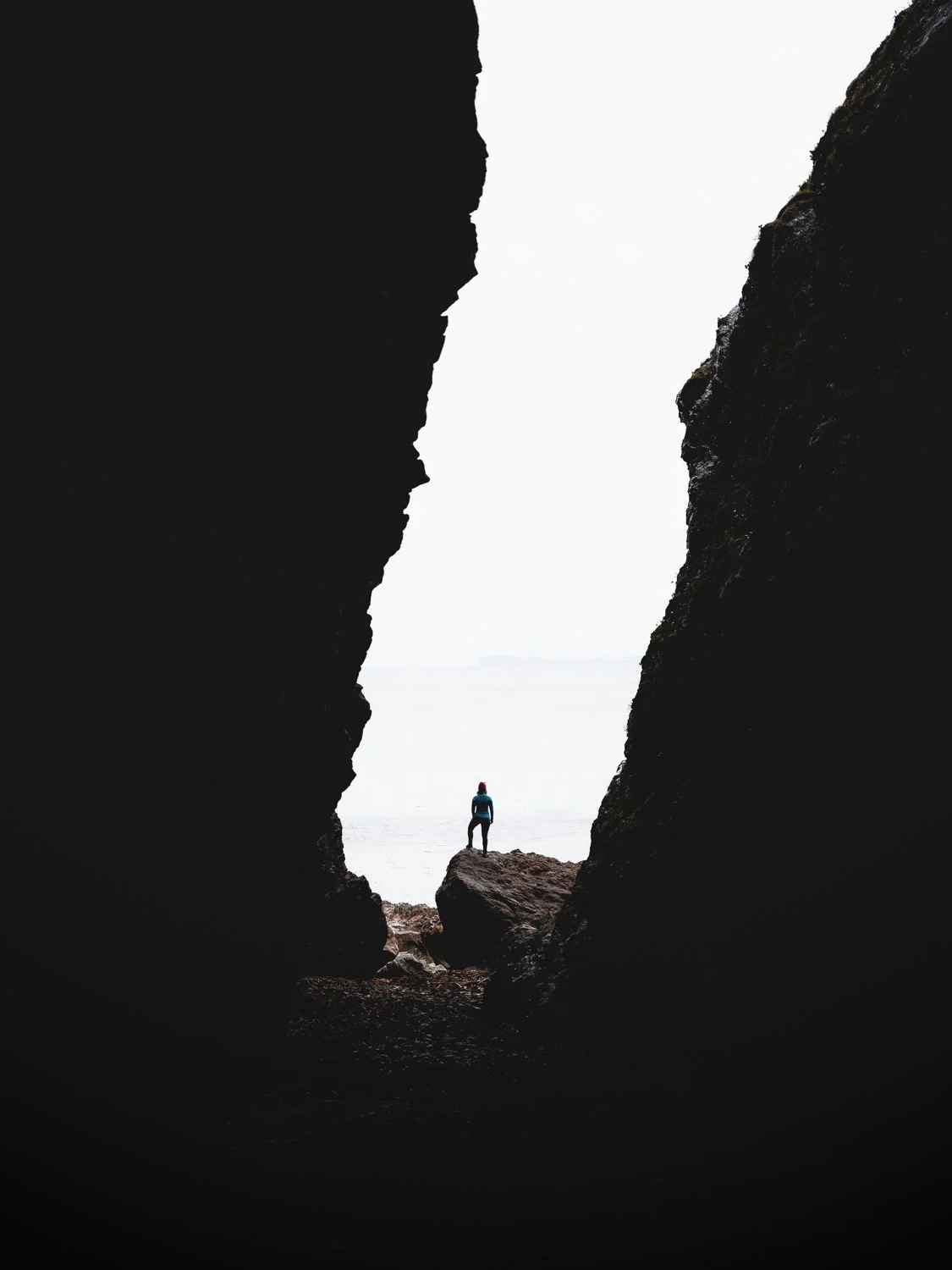 A silhouette of a person framed by cave walls.
