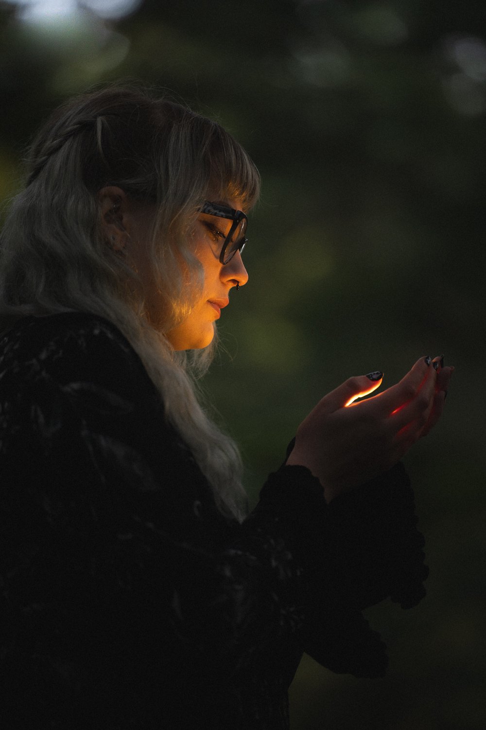 Model's face illuminated by a light in her hands.