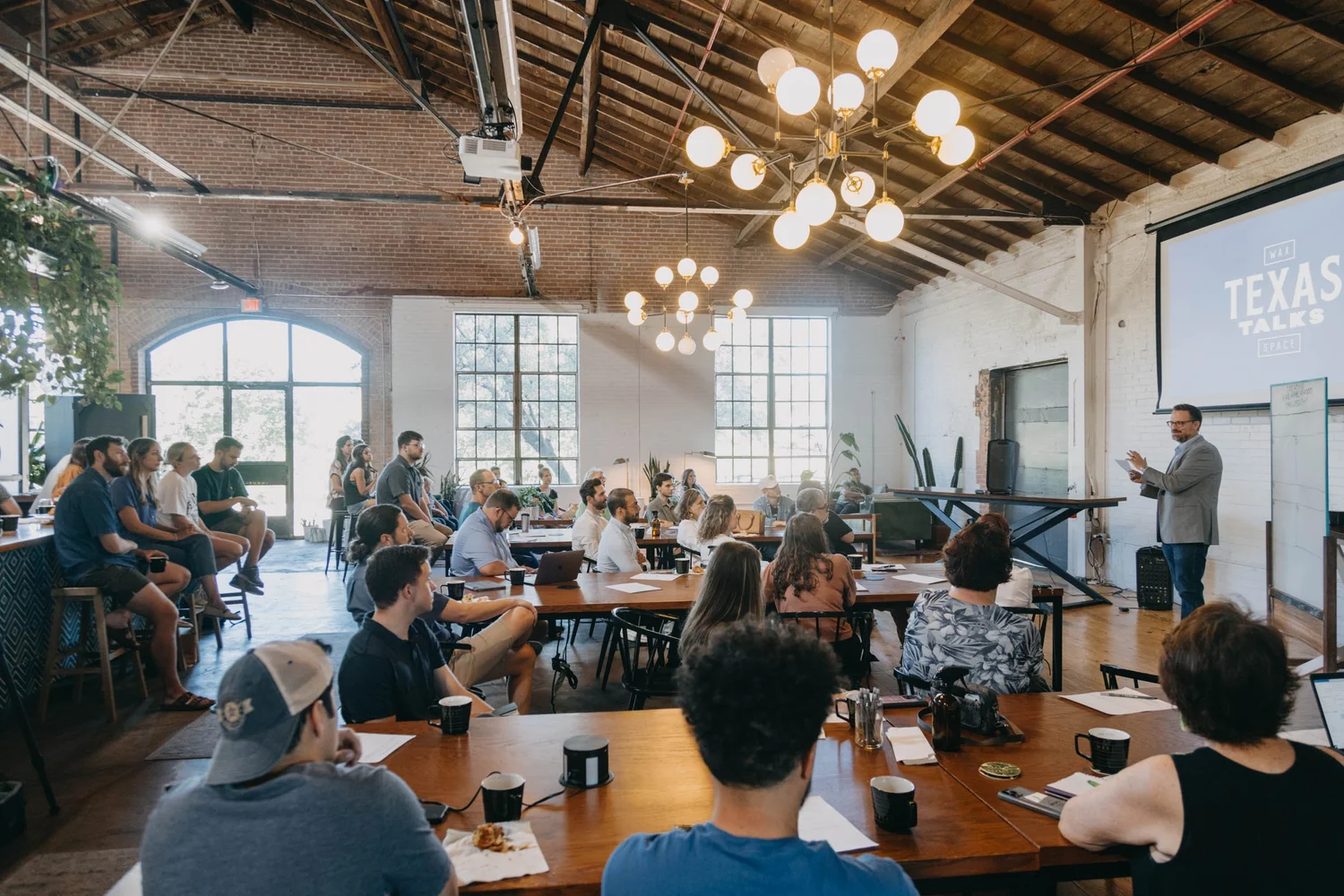 An Oak Cliff audience listening to a Texas Talks speaker inside Wax Space