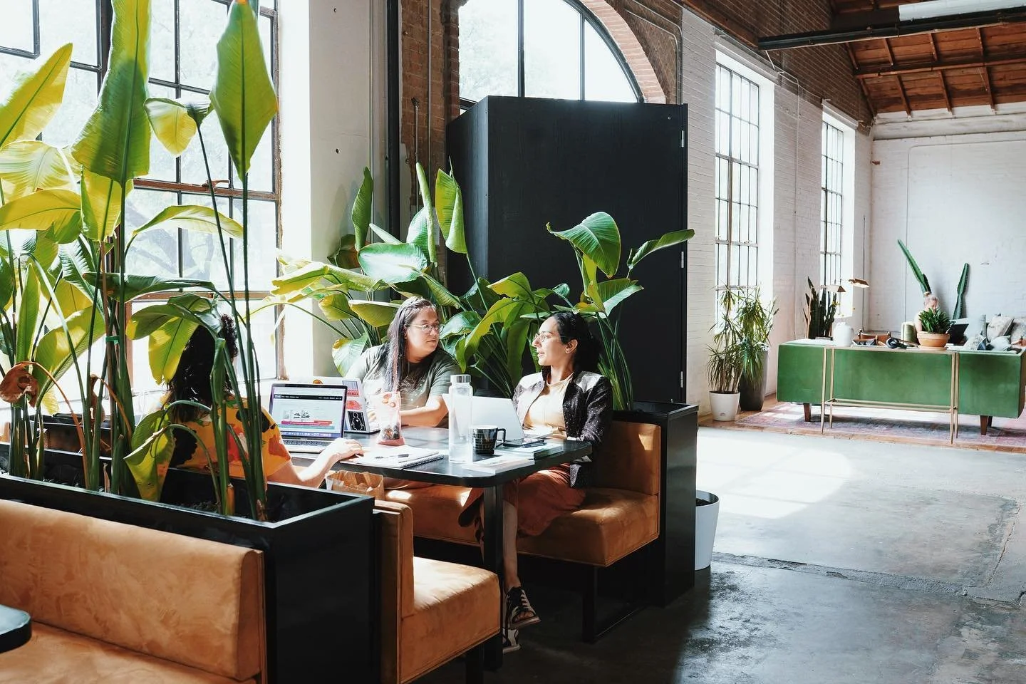 Wax Space members working together at a table in the sunlit work club
