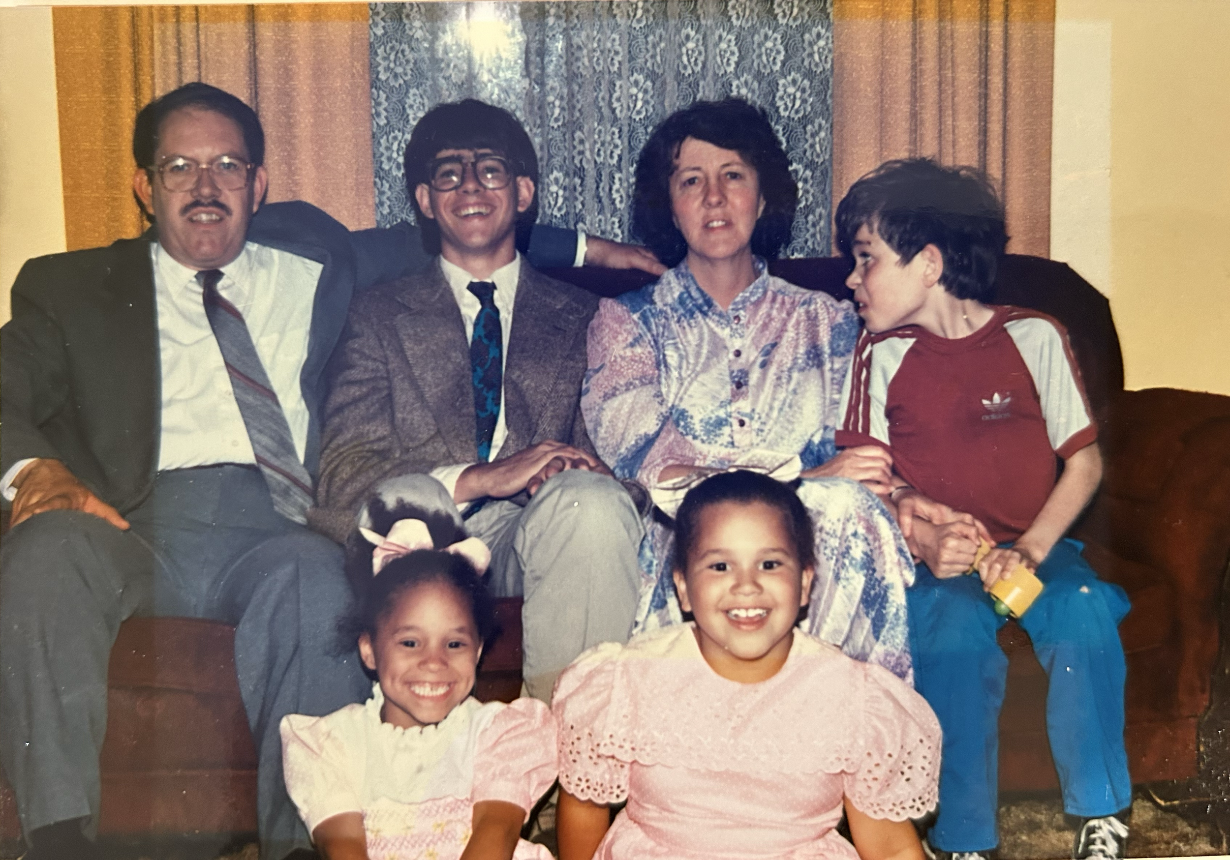 These images are shared by Melanie to offer a warm glimpse into her story and lived experience within adoption.

Description of Image:
Melanie’s family—her parents, older brothers, and younger sister—captured in her childhood home in Salt Lake City, 
