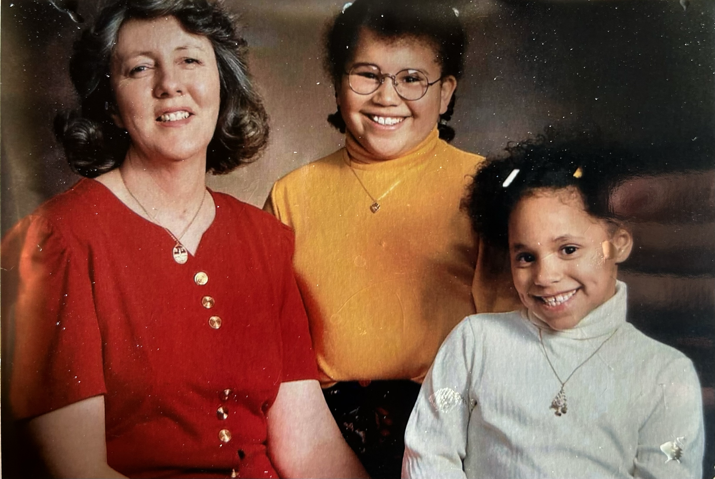 These images are shared by Melanie to offer a warm glimpse into her story and lived experience within adoption.

Description of Image:
Melanie with her mother, G. DeLynne, and her younger sister. Melanie’s mother passed away in September of 2024, lea