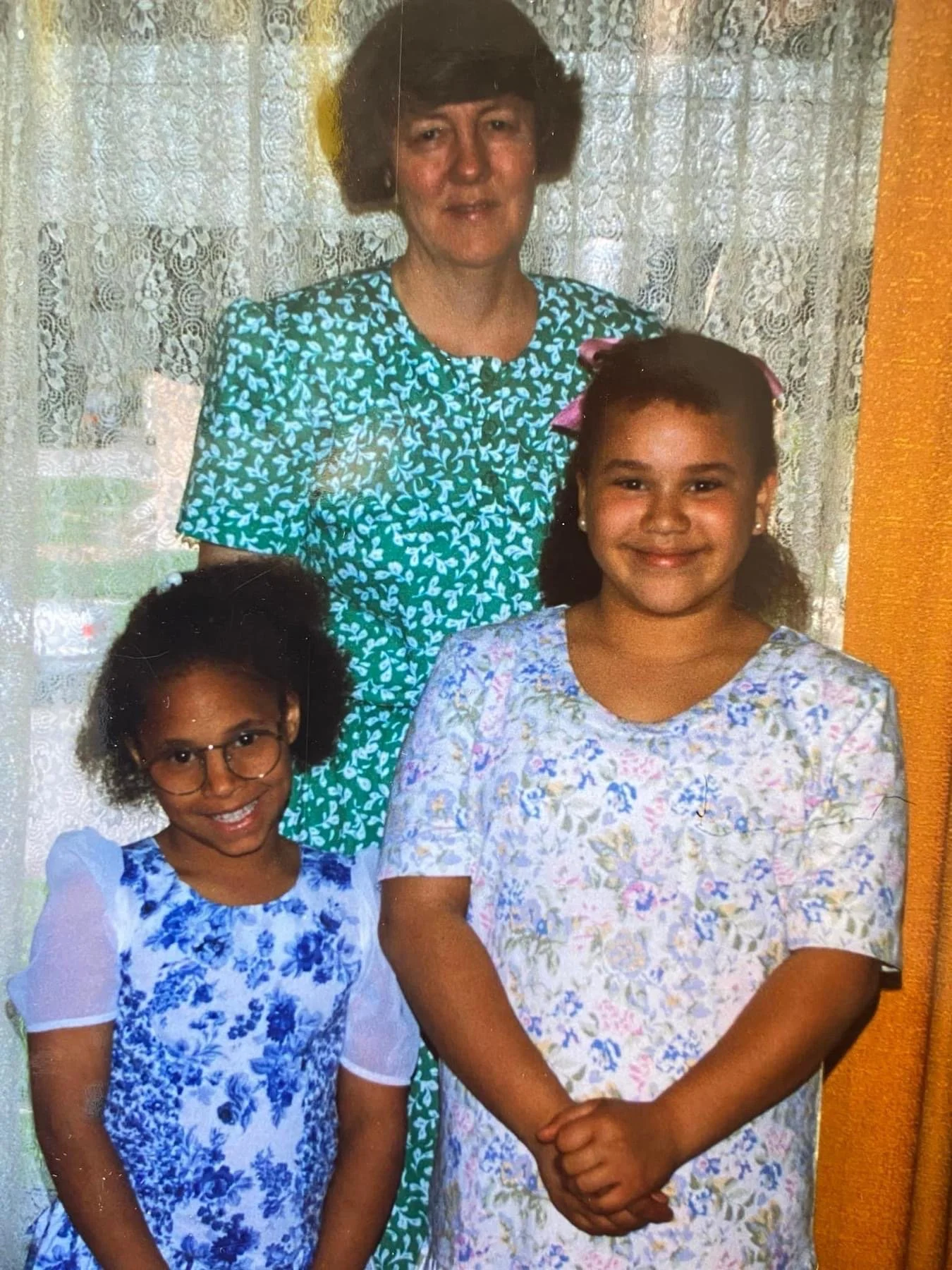 These images are shared by Melanie to offer a warm glimpse into her story and lived experience within adoption.

Description of Image: Melanie with her mother, G. DeLynne, and her younger sister. Melanie’s mother passed away in September of 2024, lea
