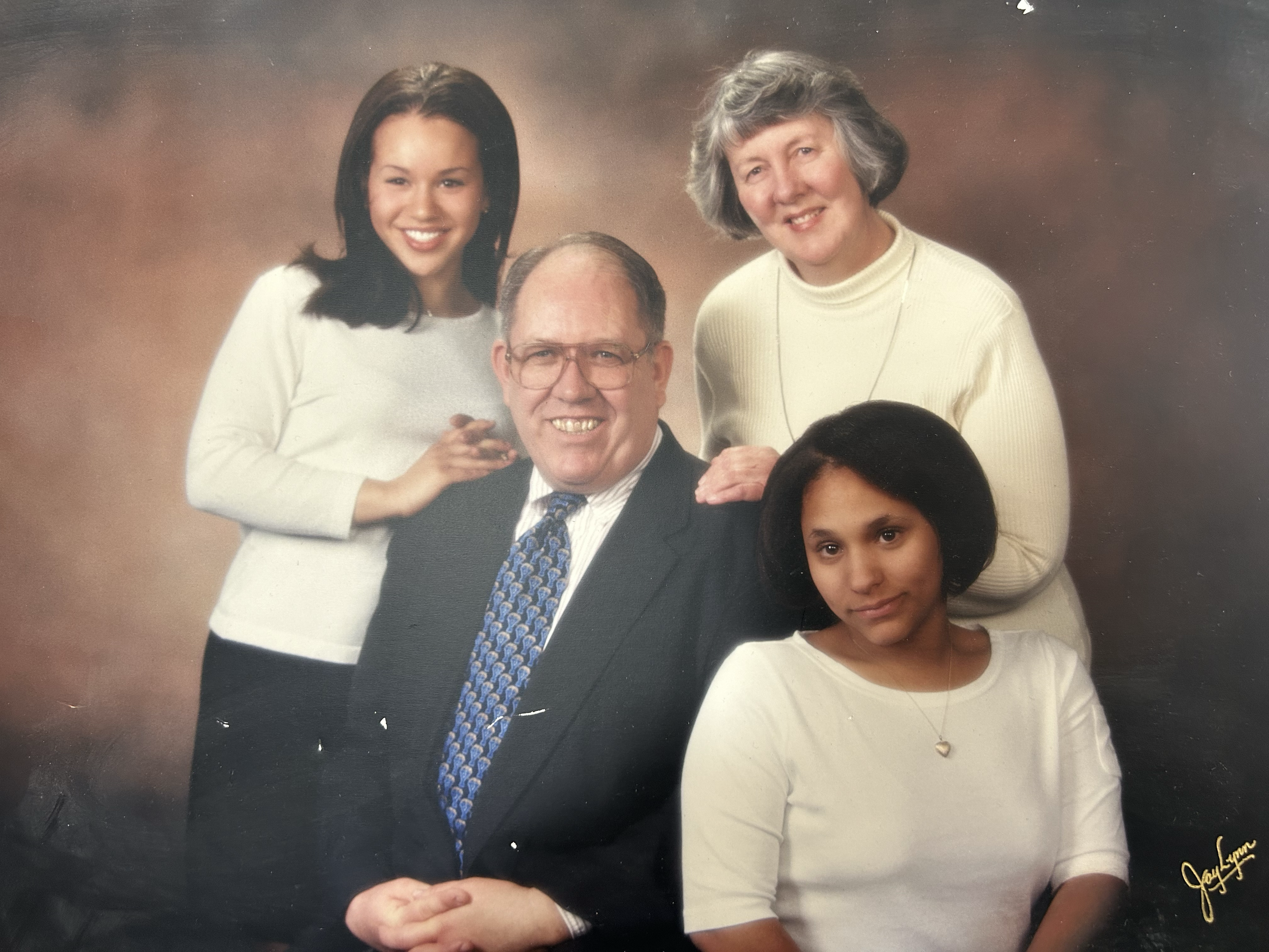 These images are shared by Melanie to offer a warm glimpse into her story and lived experience within adoption.

Description of Image:
This is a photo of Melanie with her parents and younger sister, taken during her high school years. 

Disclaimer: T