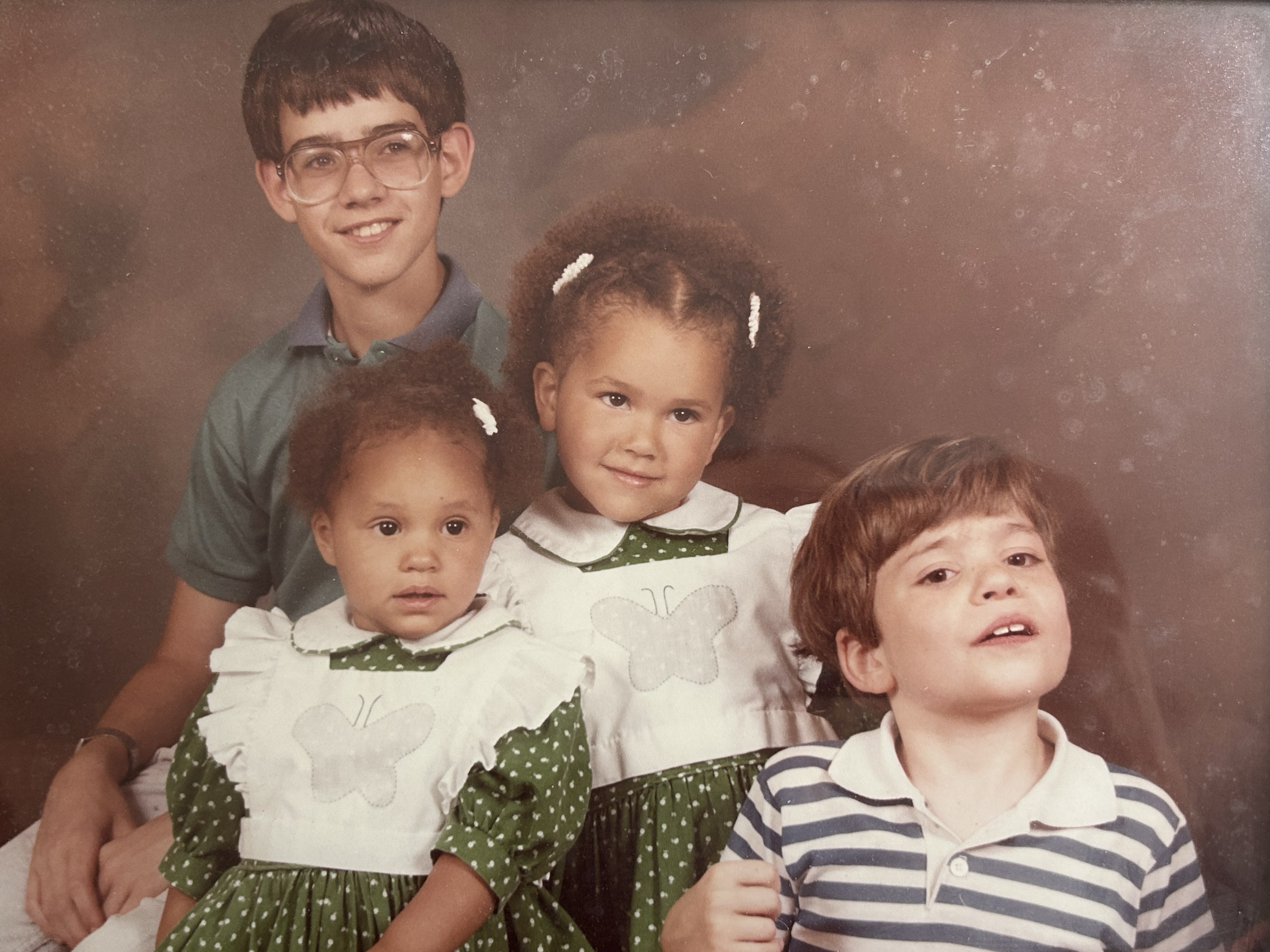 These images are shared by Melanie to offer a warm glimpse into her story and lived experience within adoption.

Description of Image:
Melanie with her brothers and sister, wearing dresses made by her mother.

Disclaimer:
These images are the persona