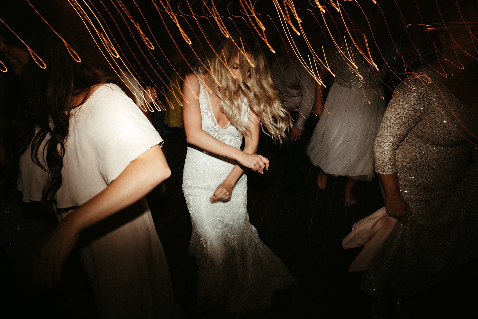 People dancing at The BRIK wedding reception with light streaks from long-exposure photography.