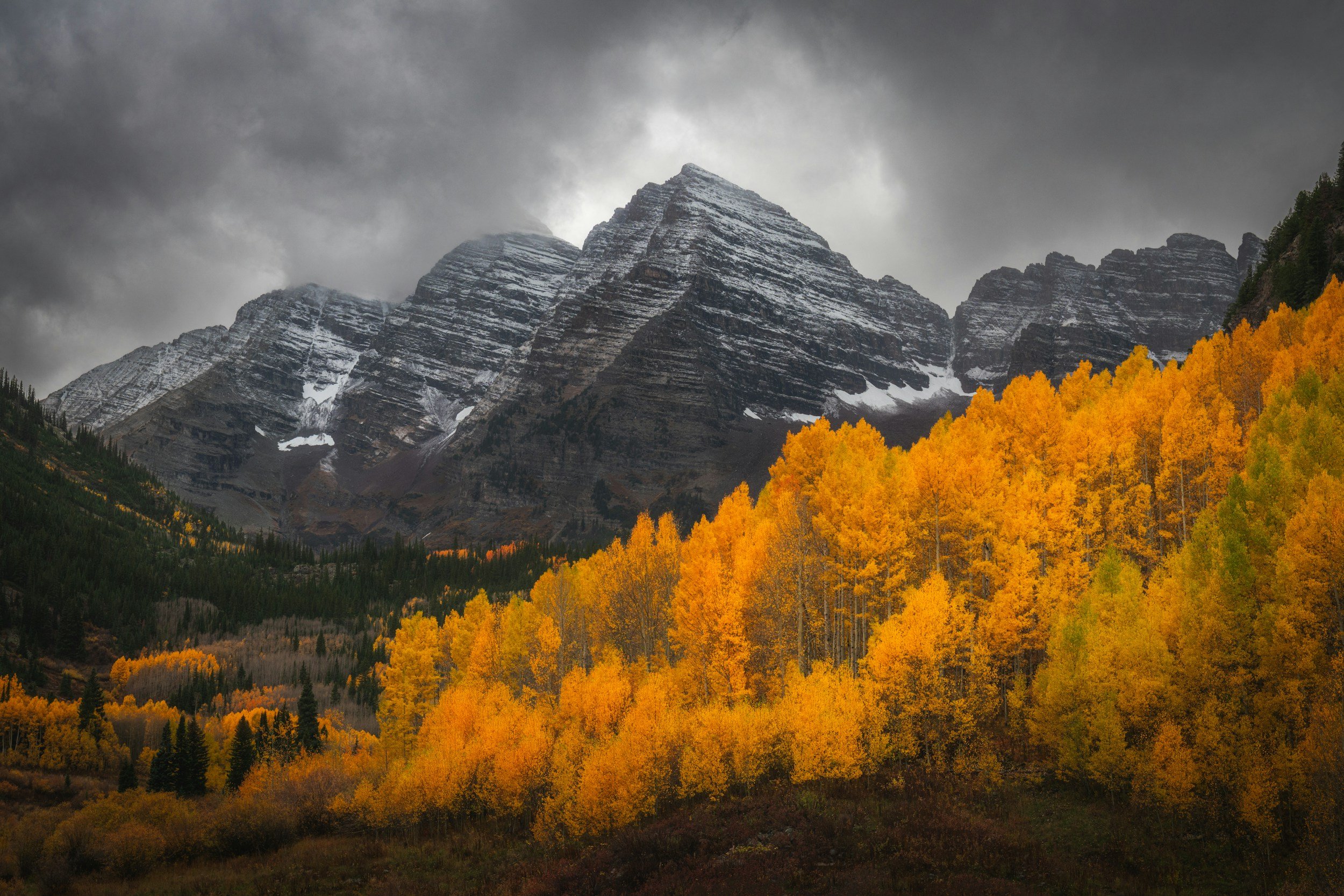The Maroon Bells mountains in Aspen during fall, with snowy mountain peaks.