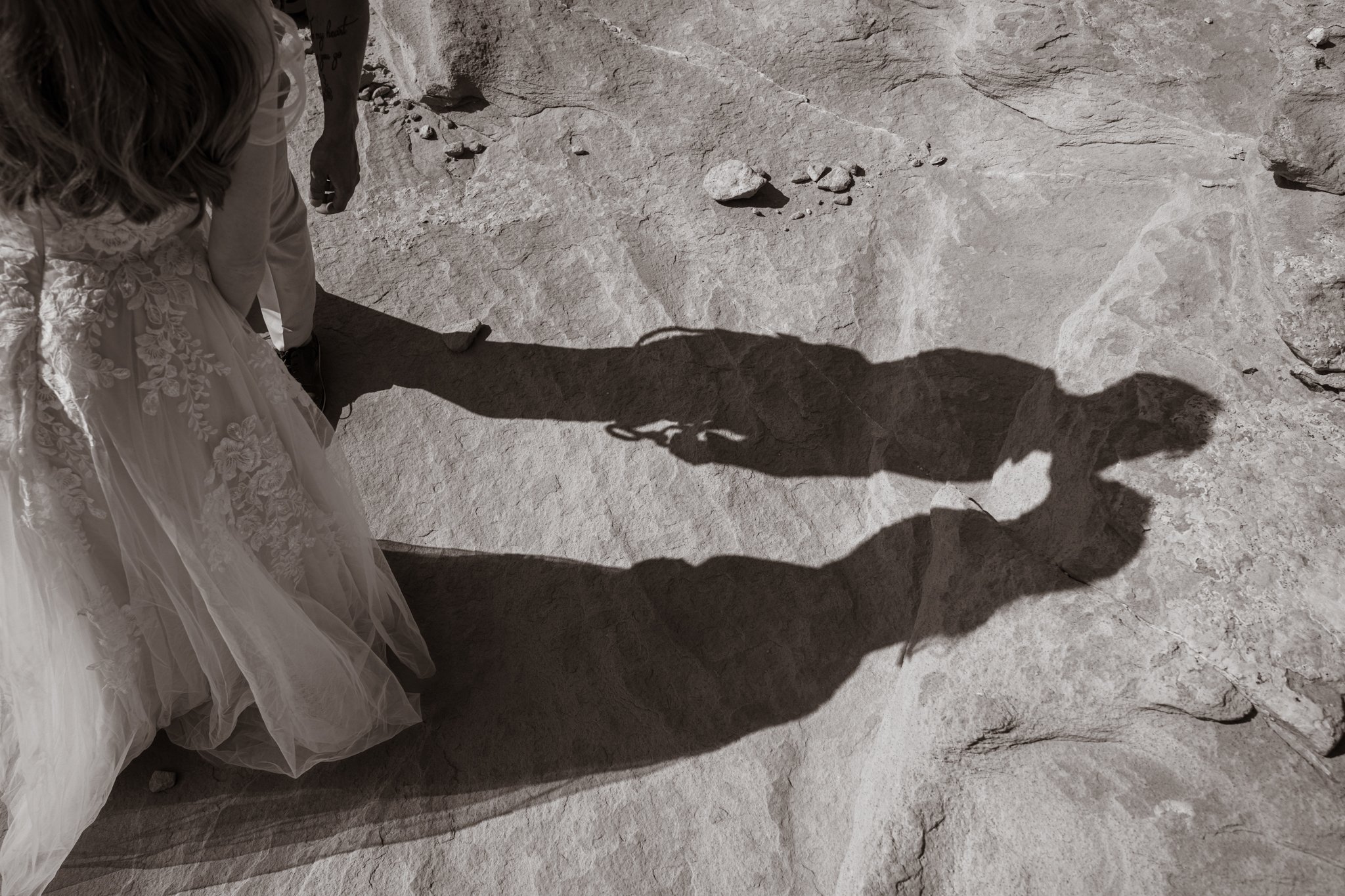 A shadow of a bride and groom as they kiss in Moab.