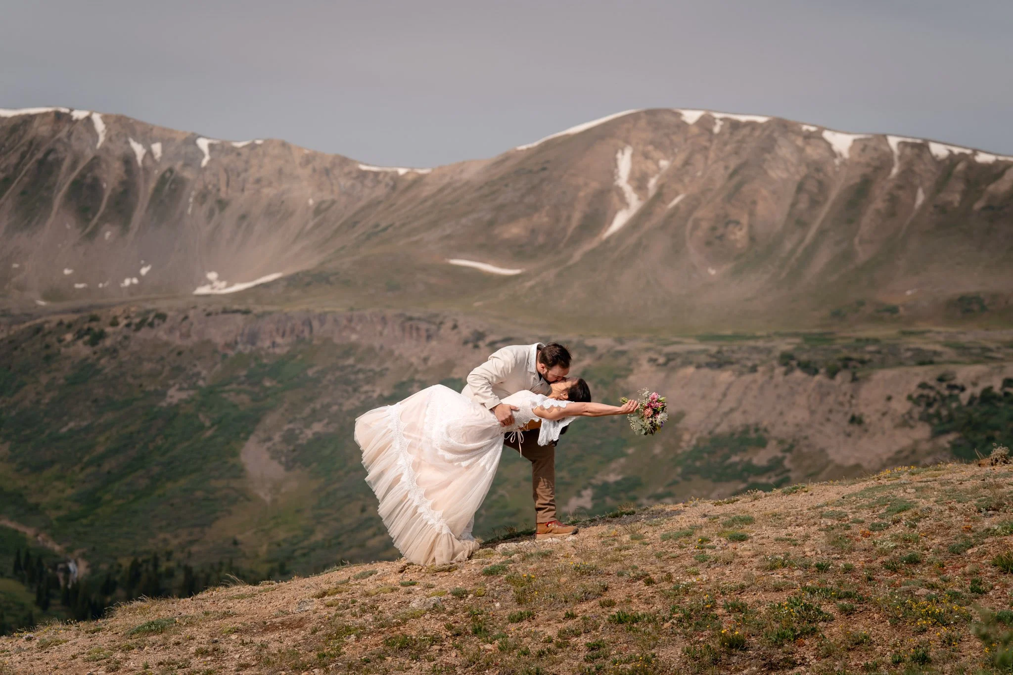 A bride and groom kiss in the mountains near Aspen, Colorado.