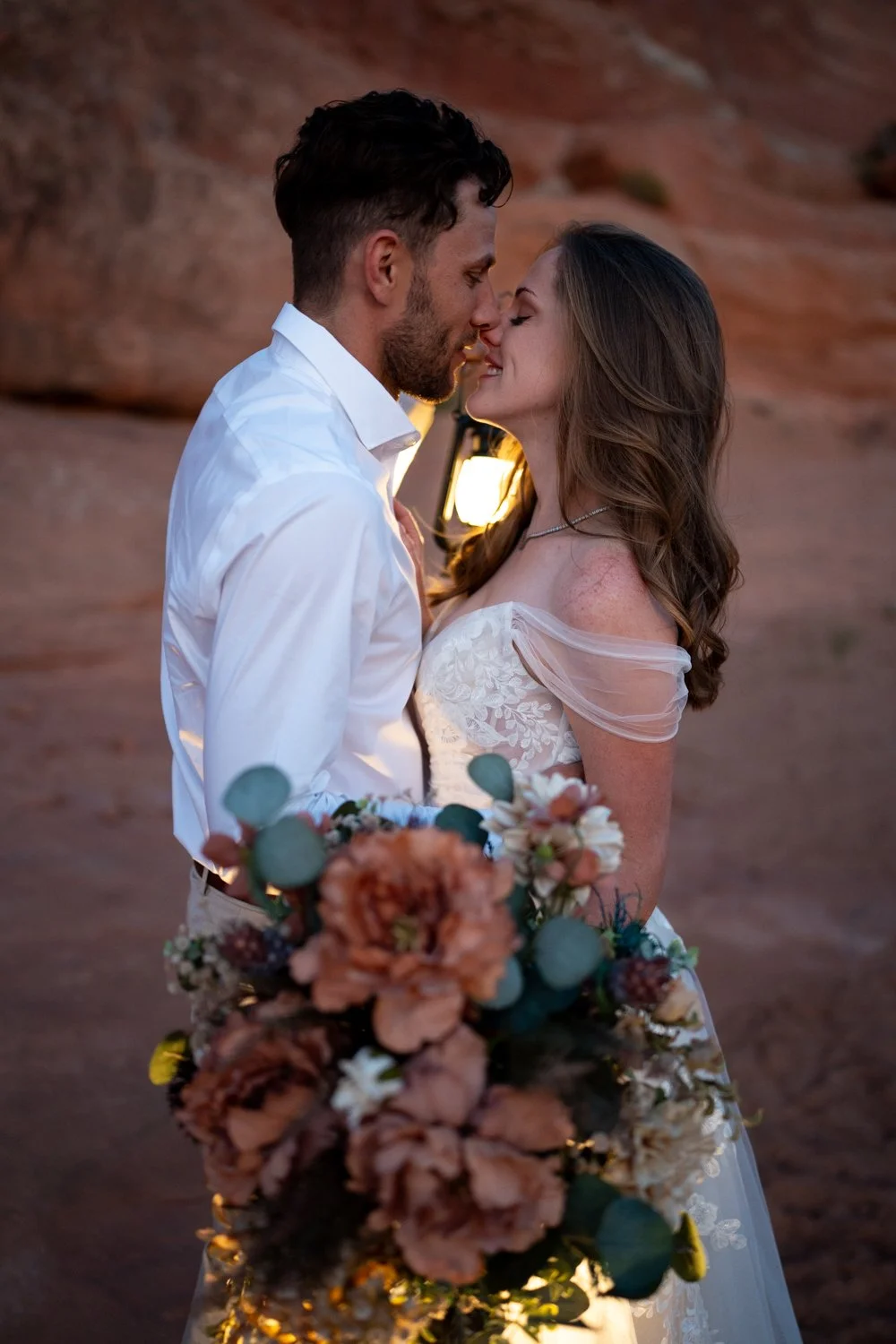 A closeup of the bride and groom close together with lanterns.