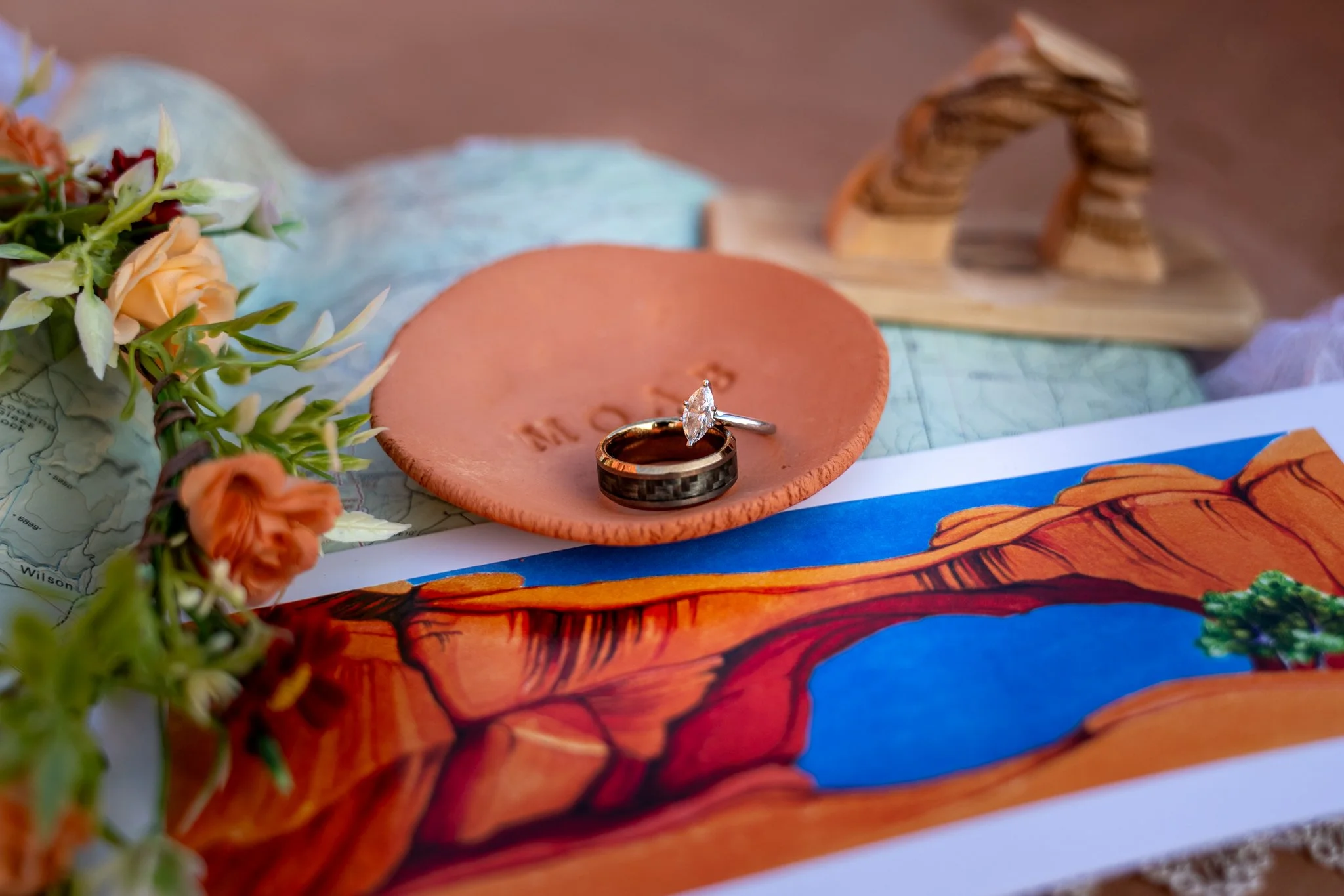 A close up of a bride and groom's rings on a flat lay in Moab.