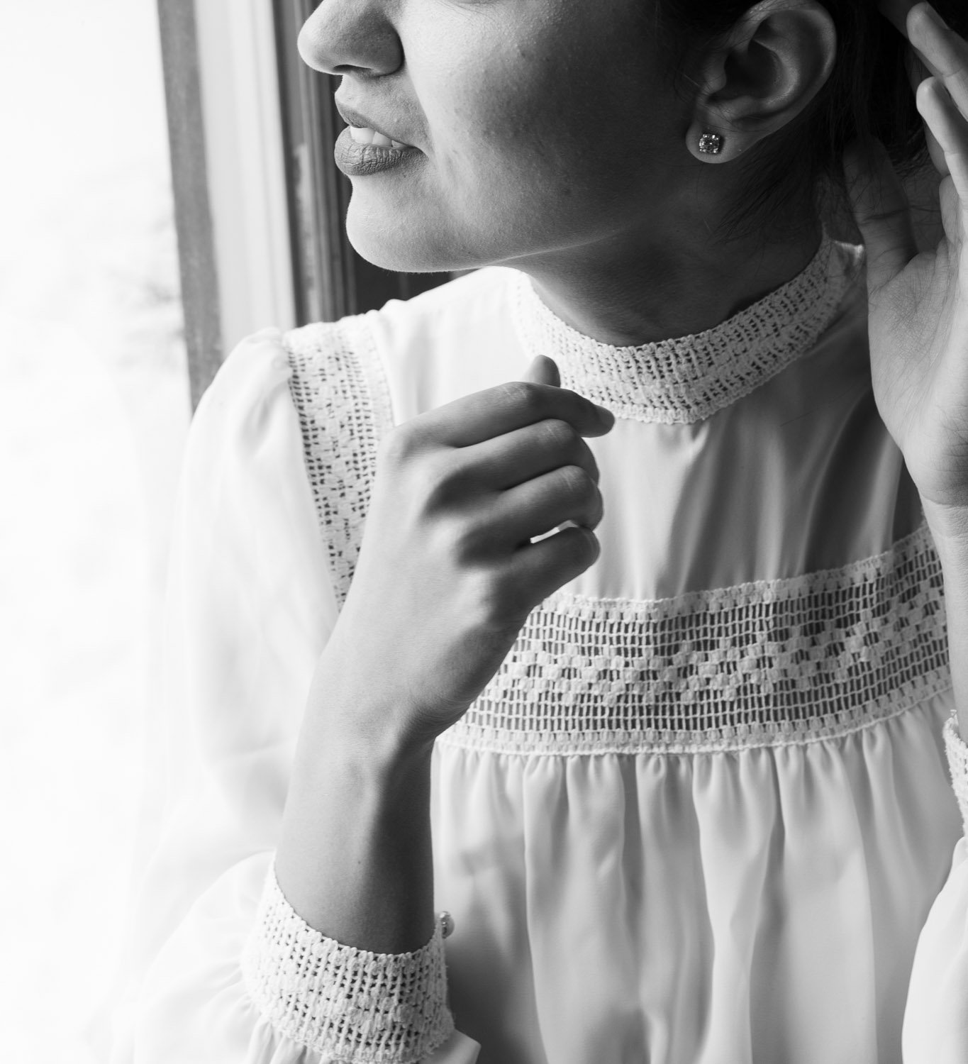 A bride looks out the window on her wedding day.