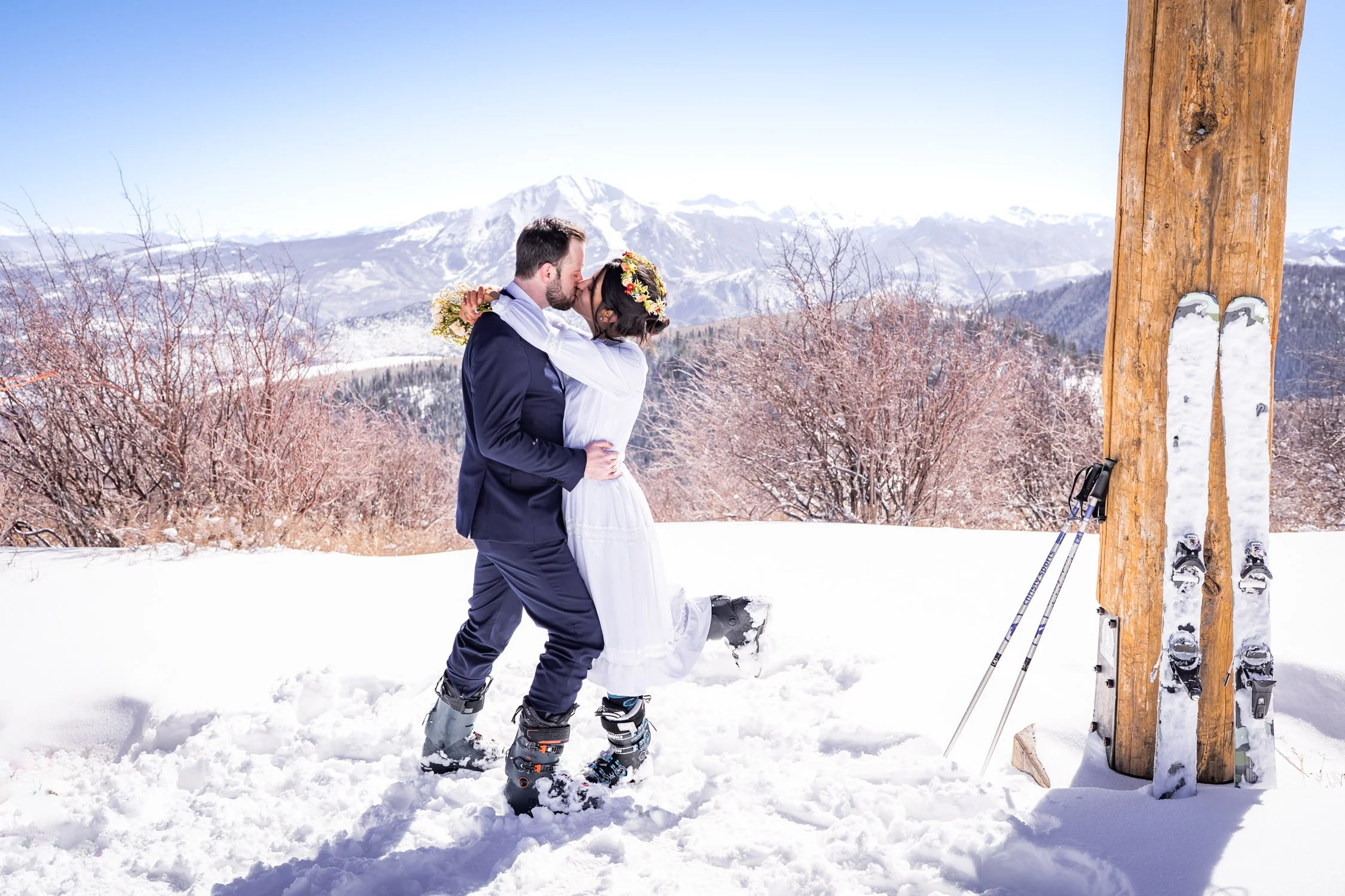A bride and groom kiss on a ski resort in Colorado.