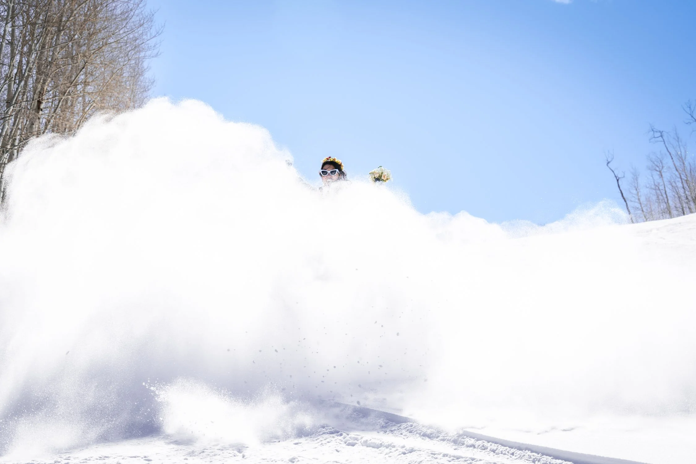 A bride is covered in snow from a snow spray!