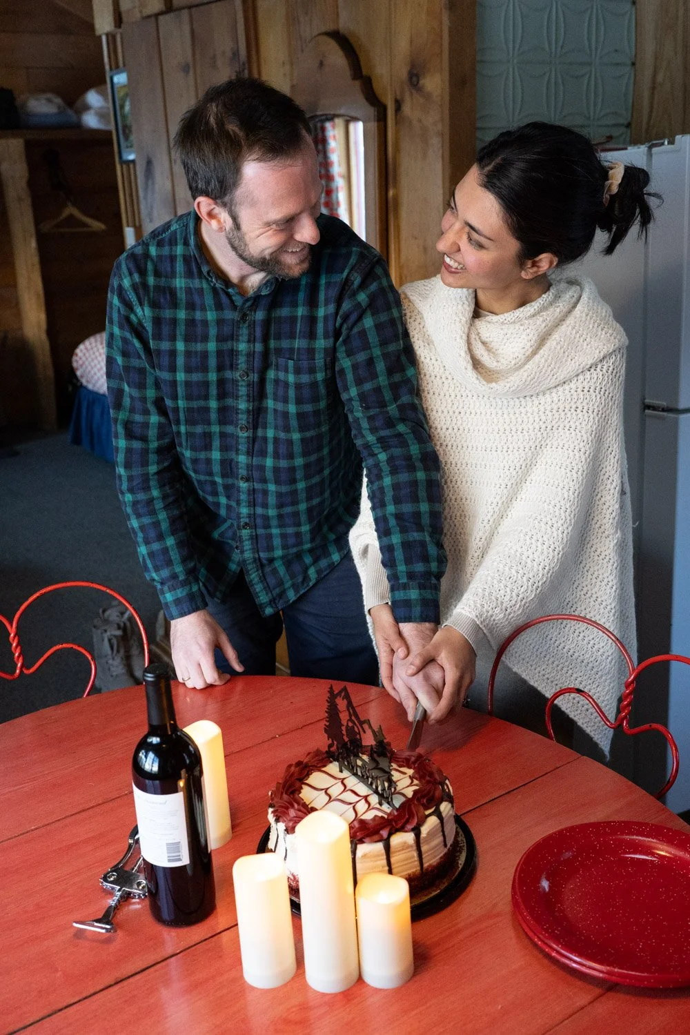 A bride and groom cut their wedding cake in a Colorado cabin.