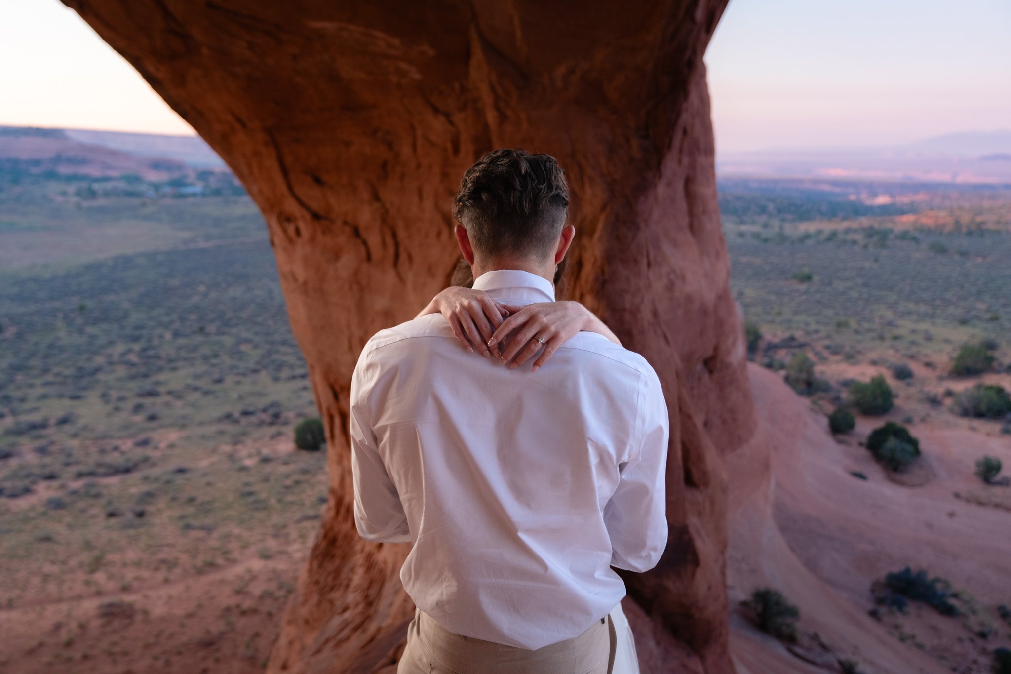 A groom holds a bride and we see her ring hand in Moab.