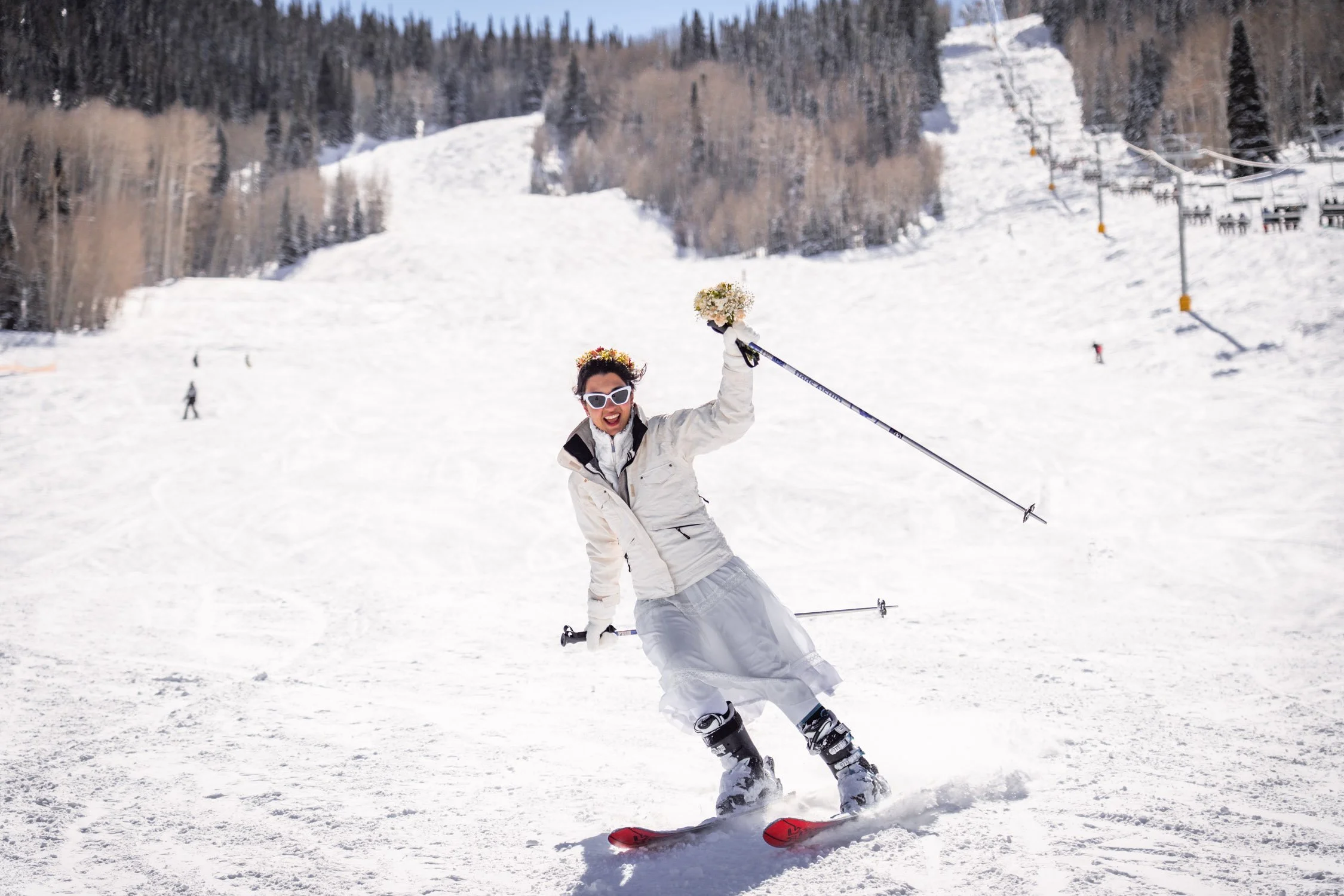 A bride happily races down a ski hill in Colorado.