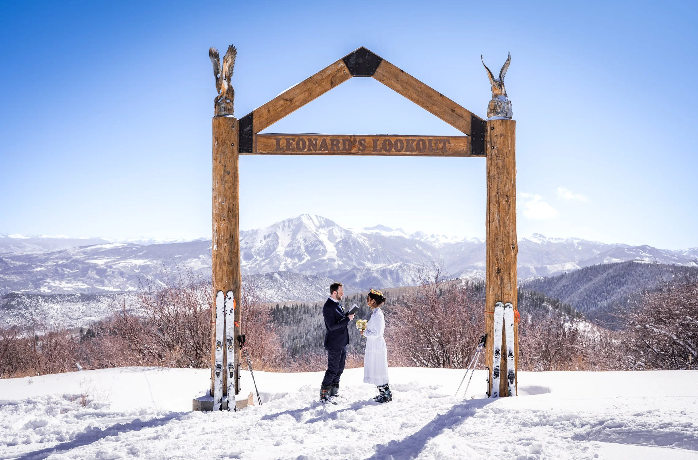 A bride and groom exchange vows on a snowy mountain ski resort in Colorado.