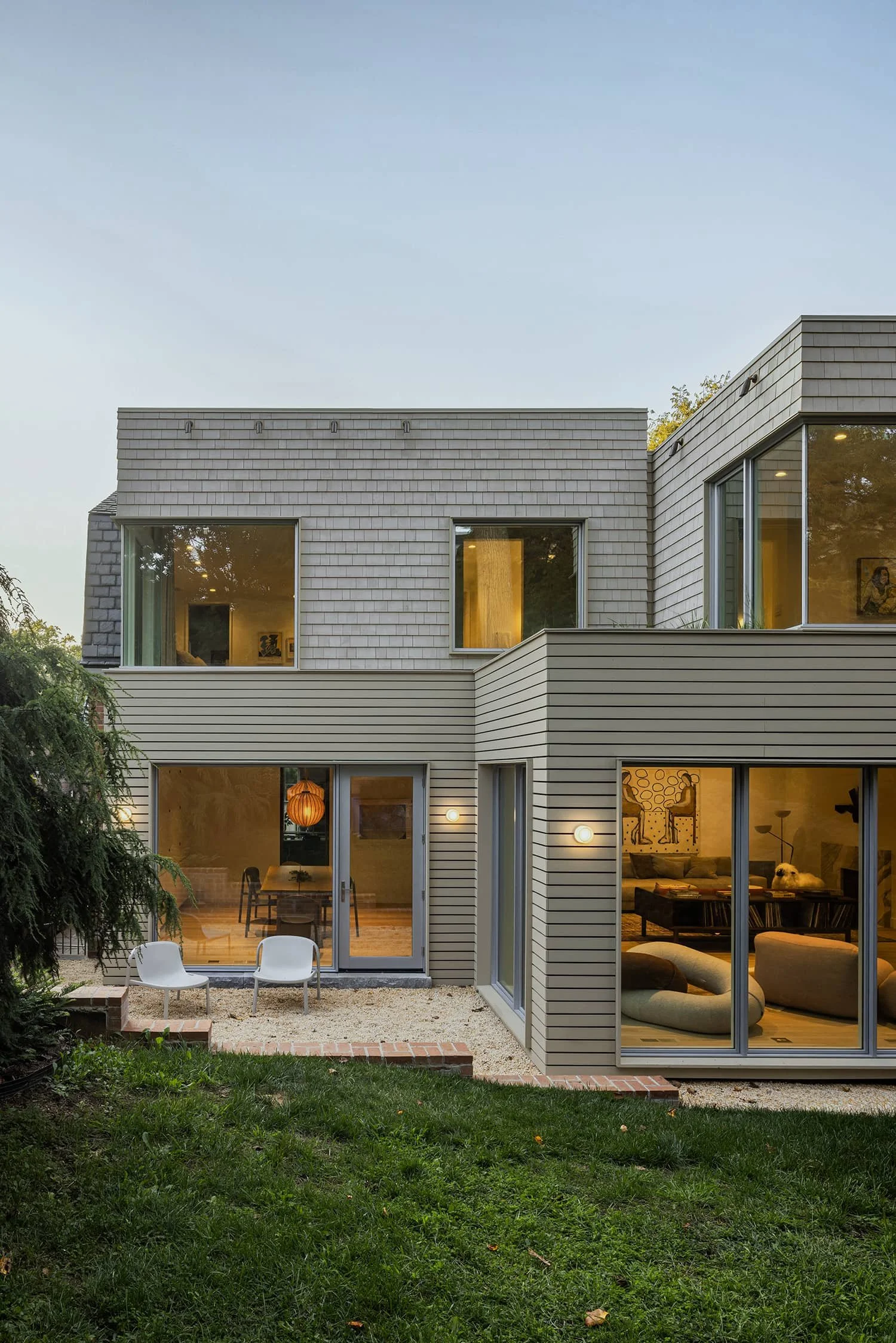 Rear exterior showing glass doors opening to terrace in modern Kalorama residence by Fowlkes Studio.