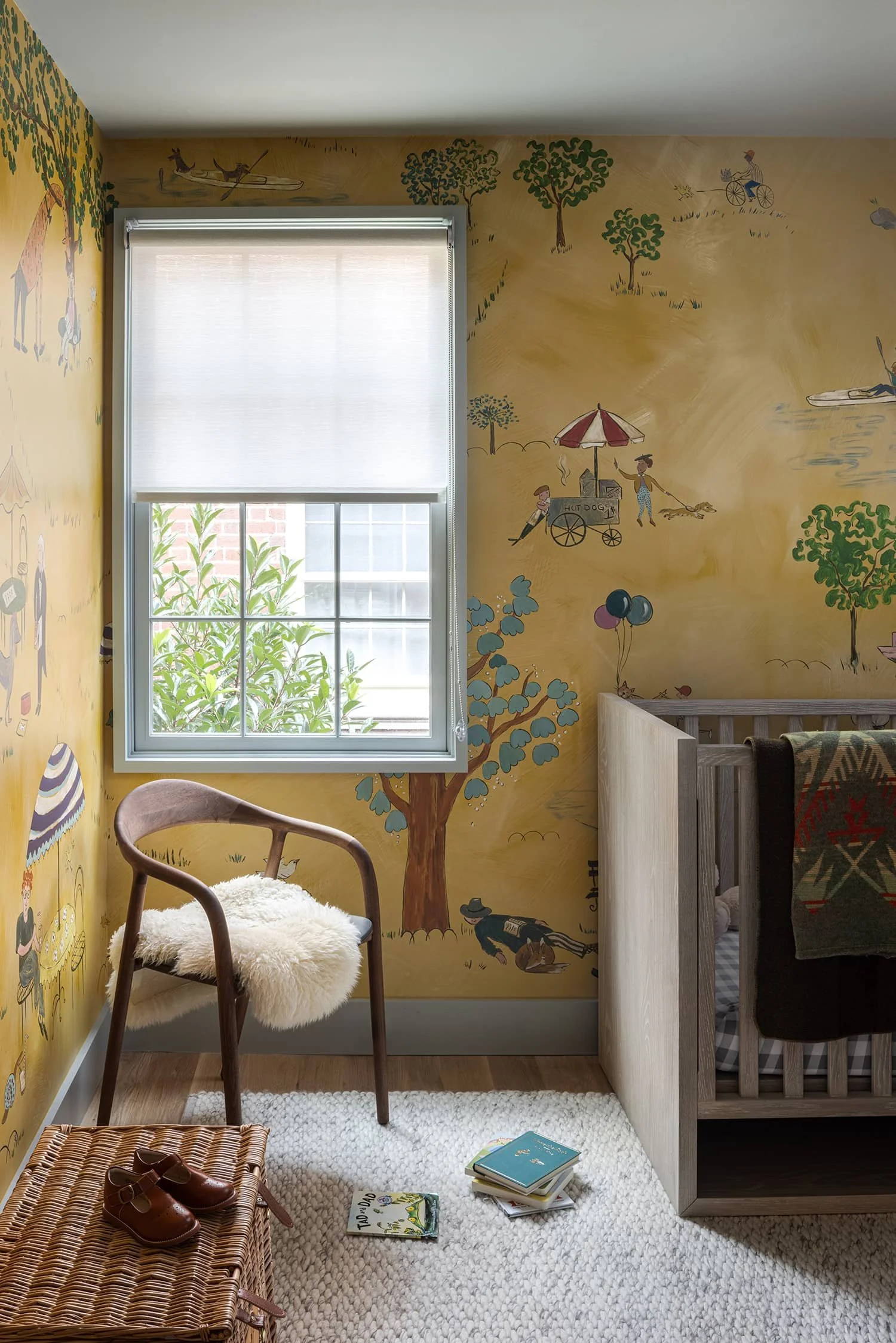 Child's nursery wallpapered in whimsical illustrated wallpaper and modern furniture designed by Fowlkes Studio in Washington, DC.