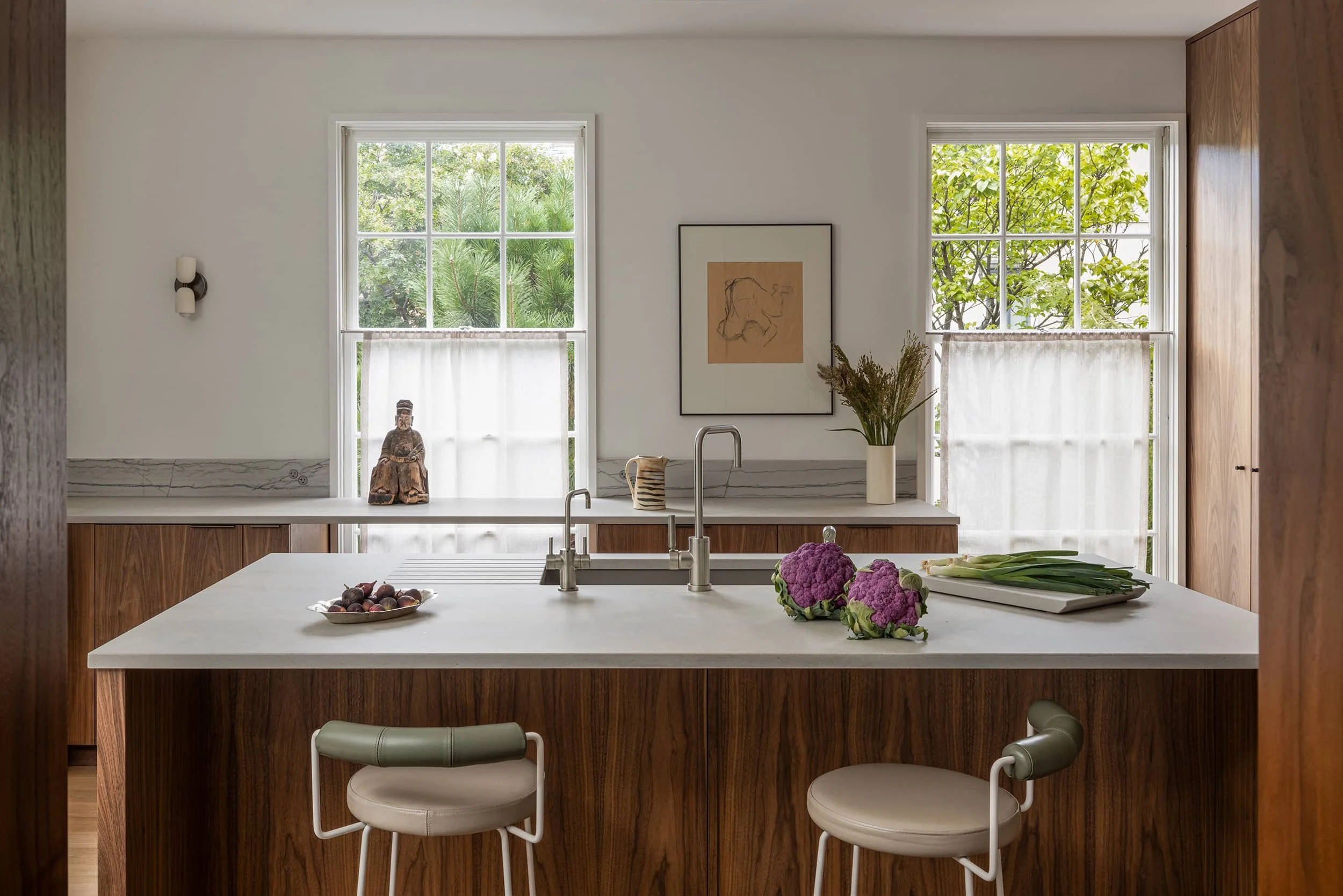Minimalist walnut kitchen with island and modern stools designed by Fowlkes Studio in Kalorama Washington, DC.