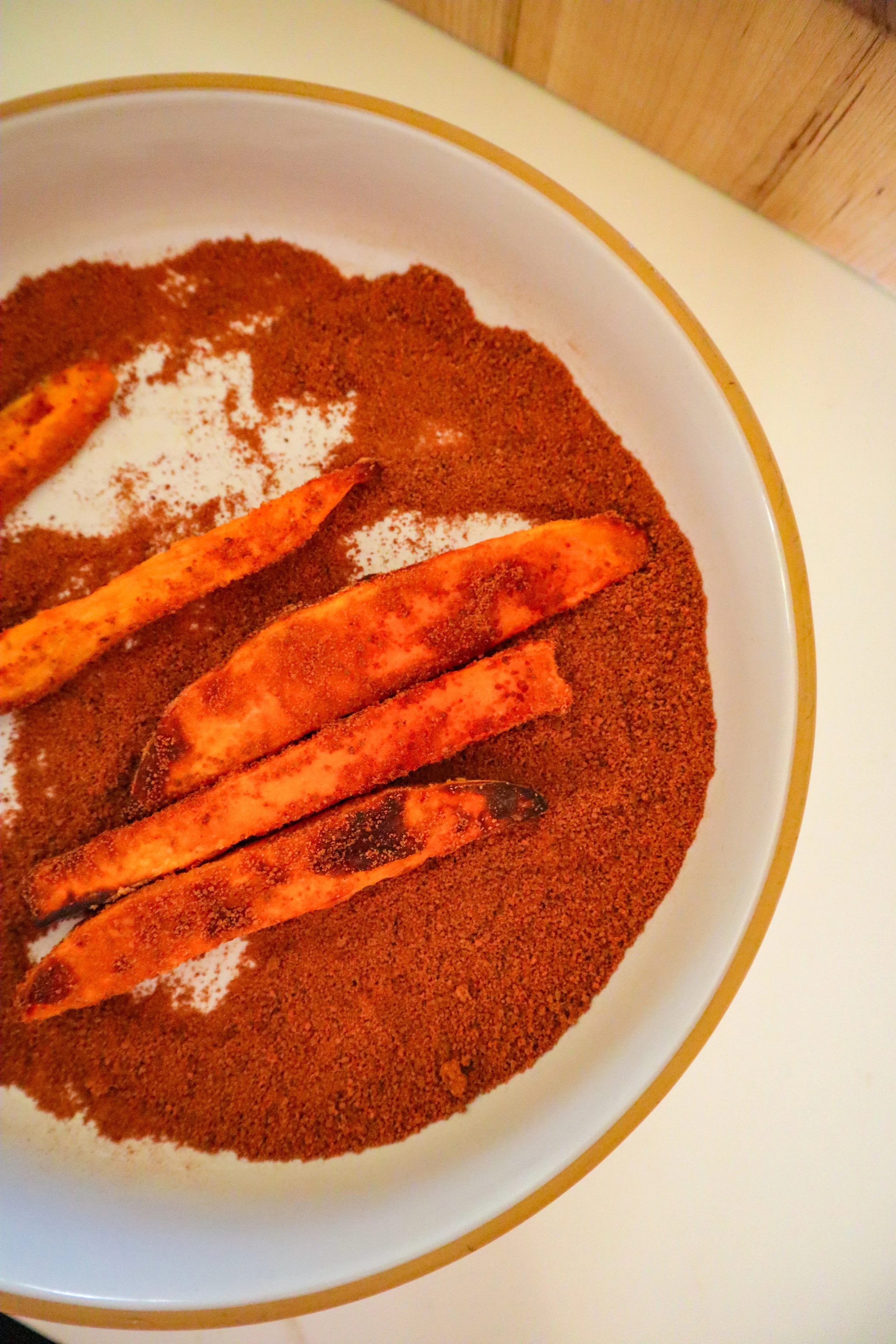   Sweet potato fries being coated in cinnamon sugar mixture after air frying.  