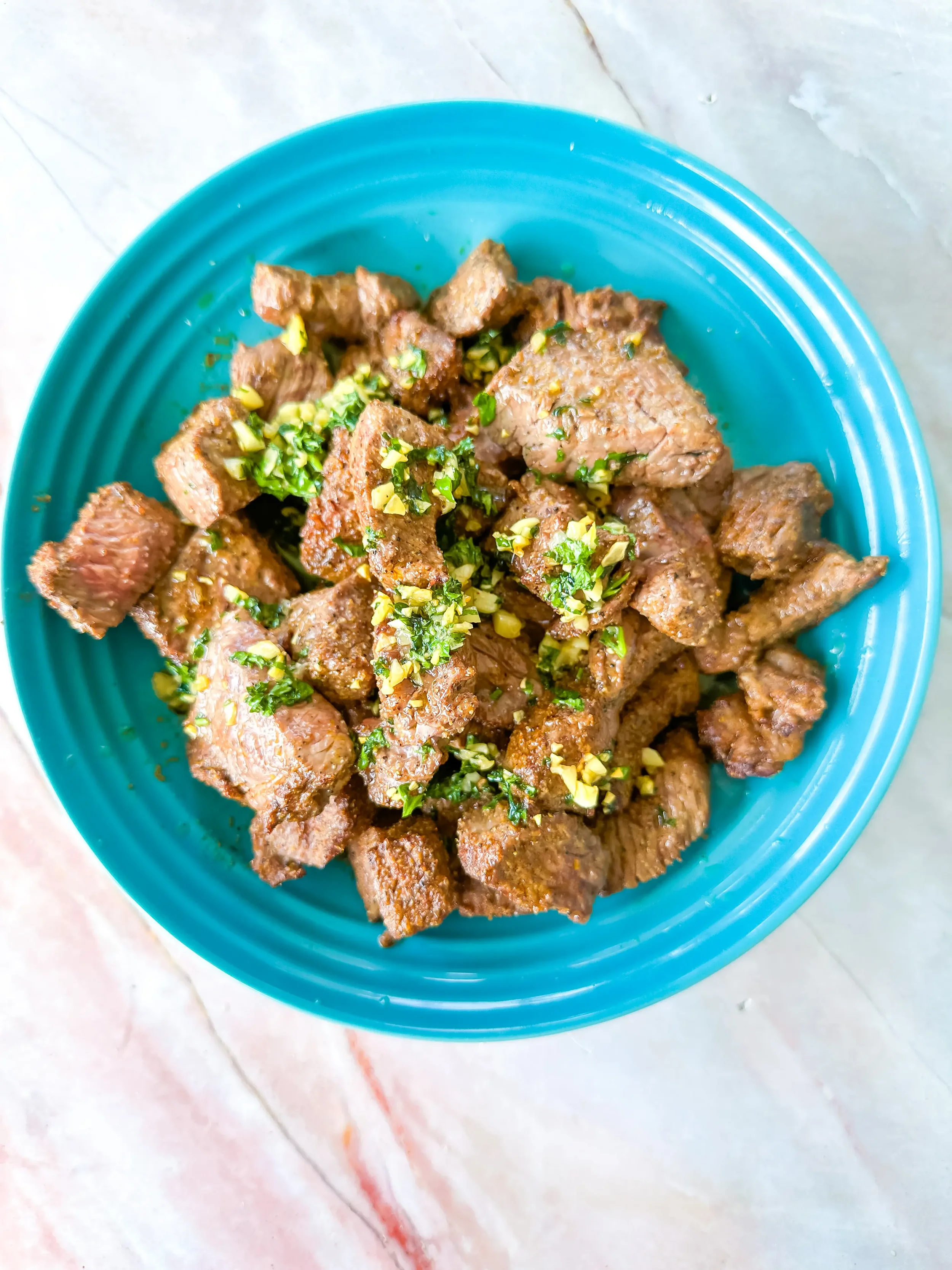 steak bites with butter and garlic sauce on a plate