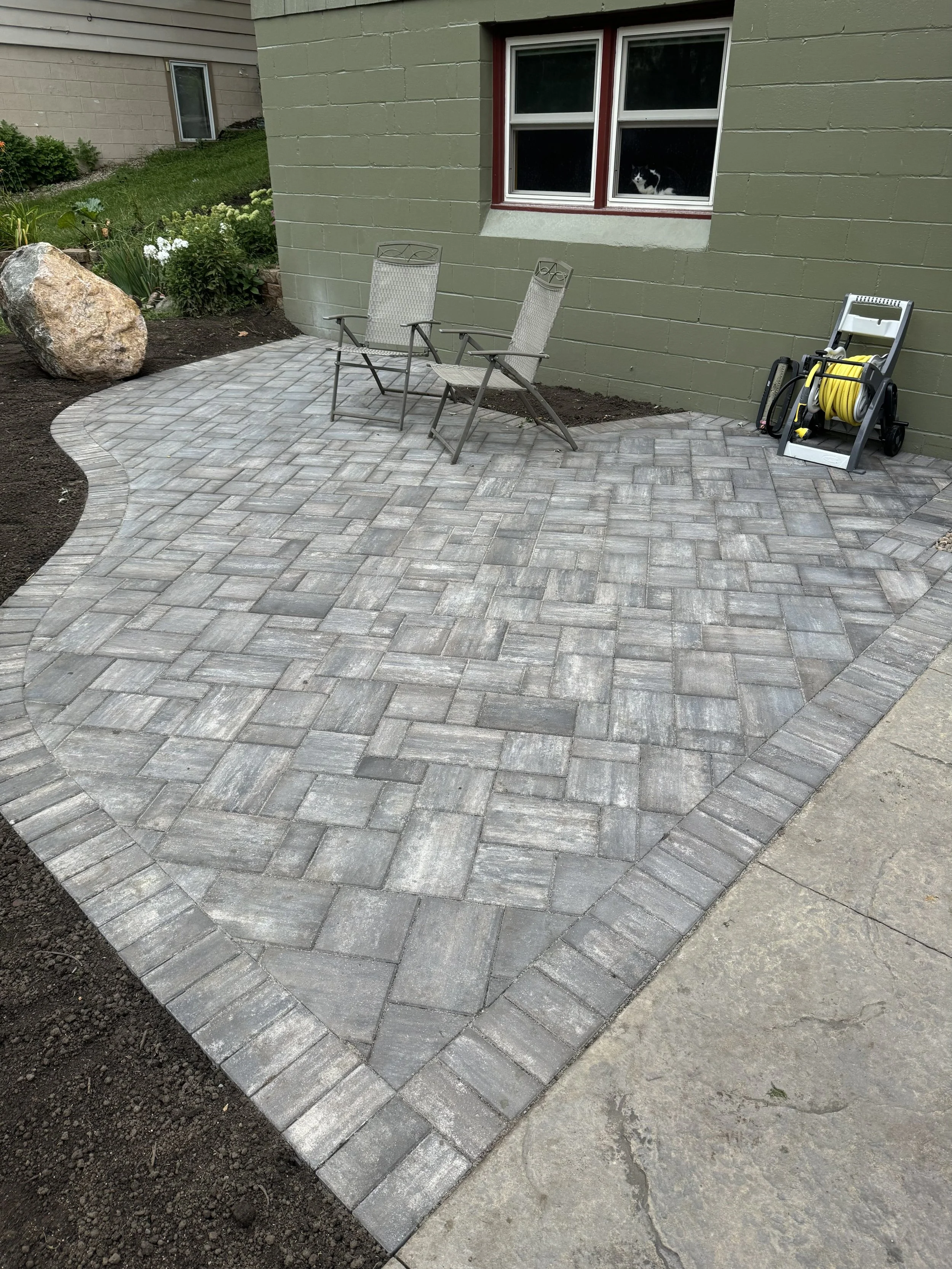 MB Landscapes installed a paved outdoor patio with gray pavers.