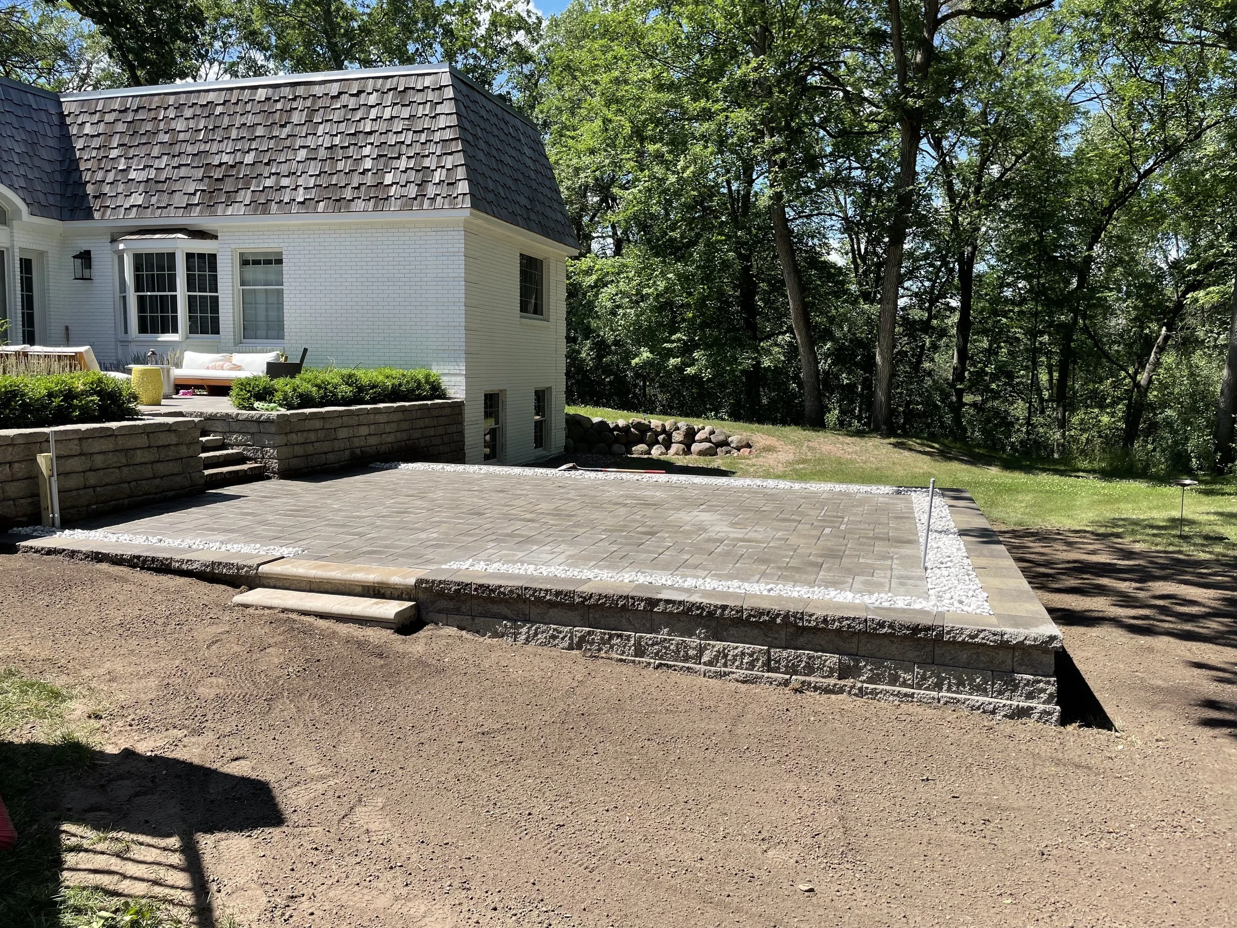 MB Landscapes installed a new raised paver patio area including steps leading up to the patio area for access.