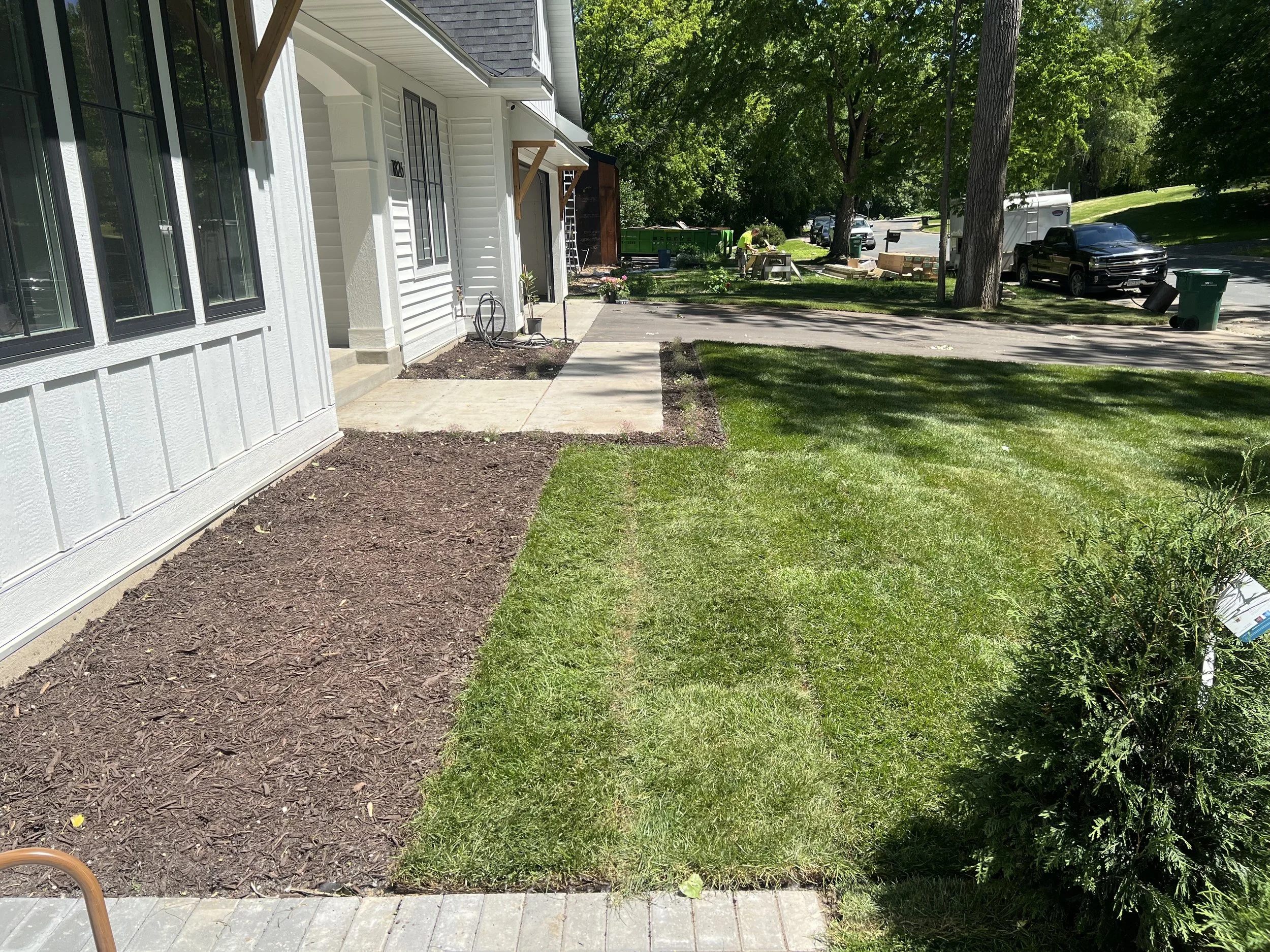 MB Landscapes installed in front of a house with a garden bed, freshly laid sod.