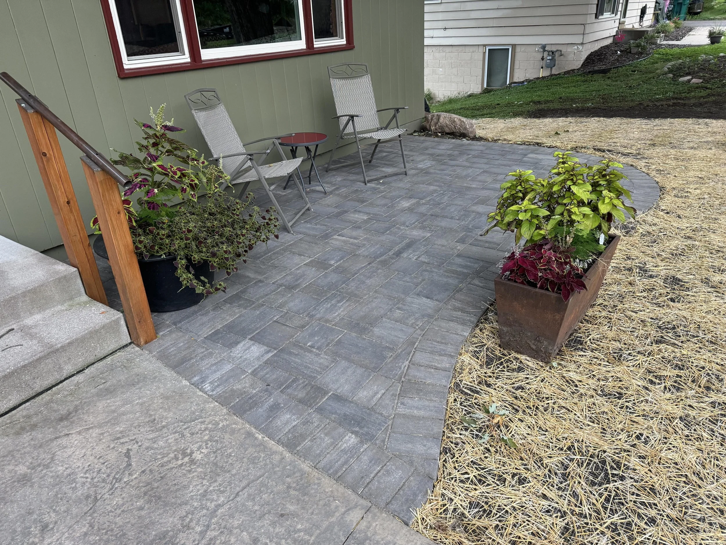 MB Landscapes installed newly paved backyard patio with pavers, straw mat and seeding, and stone edging.
