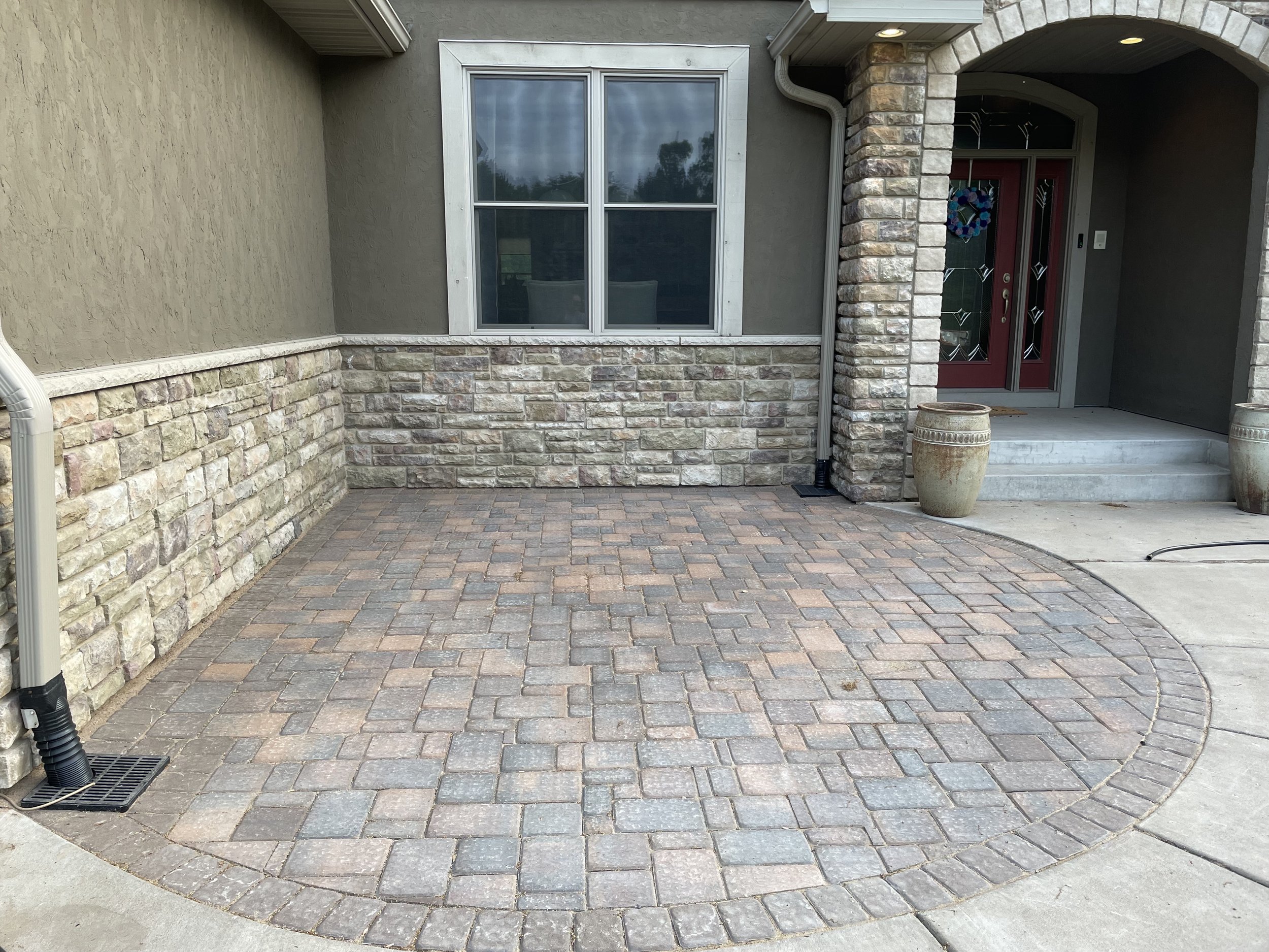 MB Landscapes installed front porch with paver pad and stone wall.