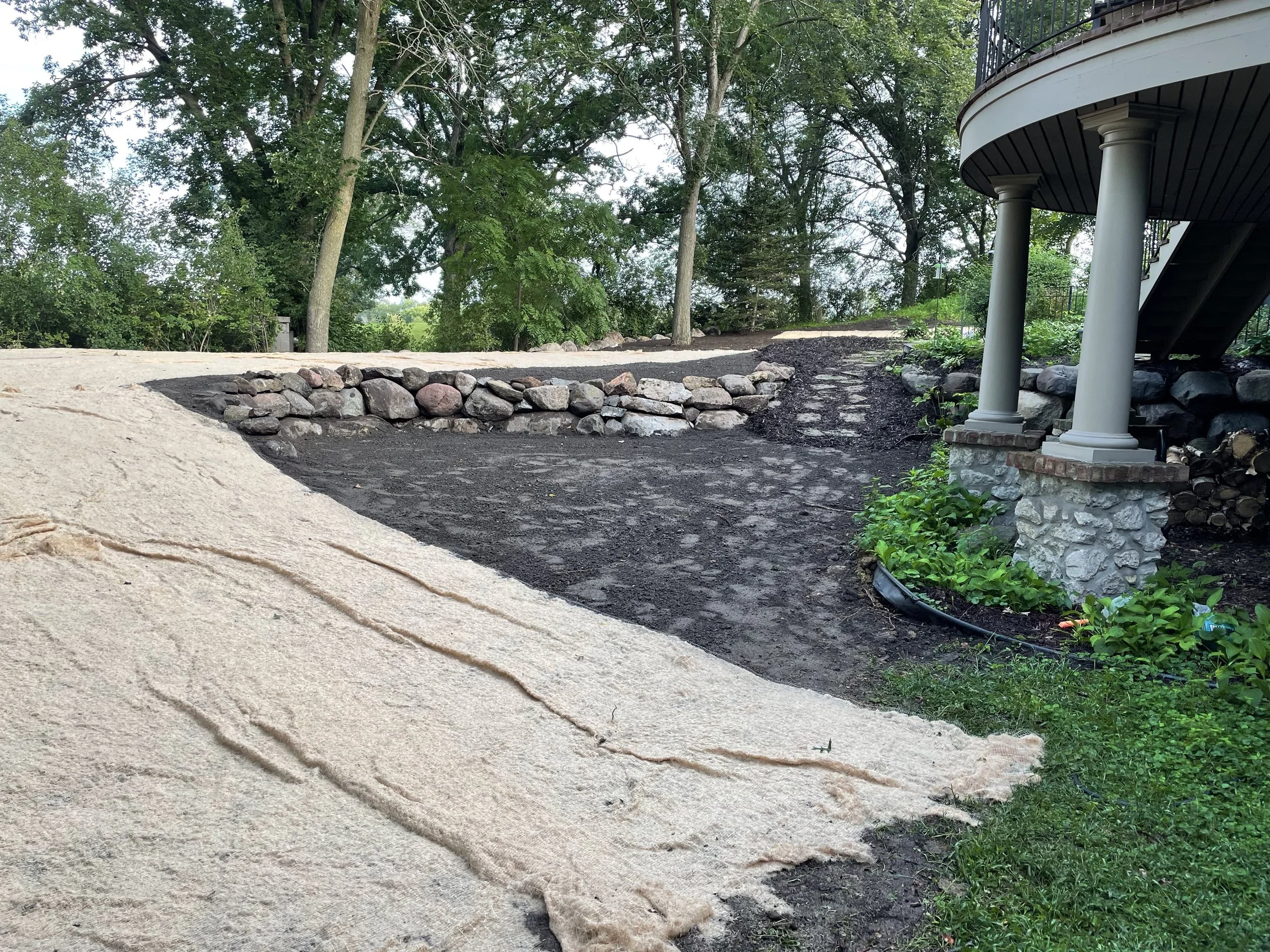 MB Landscapes installed a brand new boulder wall, with regrading to redirect water properly away from the foundation. Erosion mats and seeding were also installed.