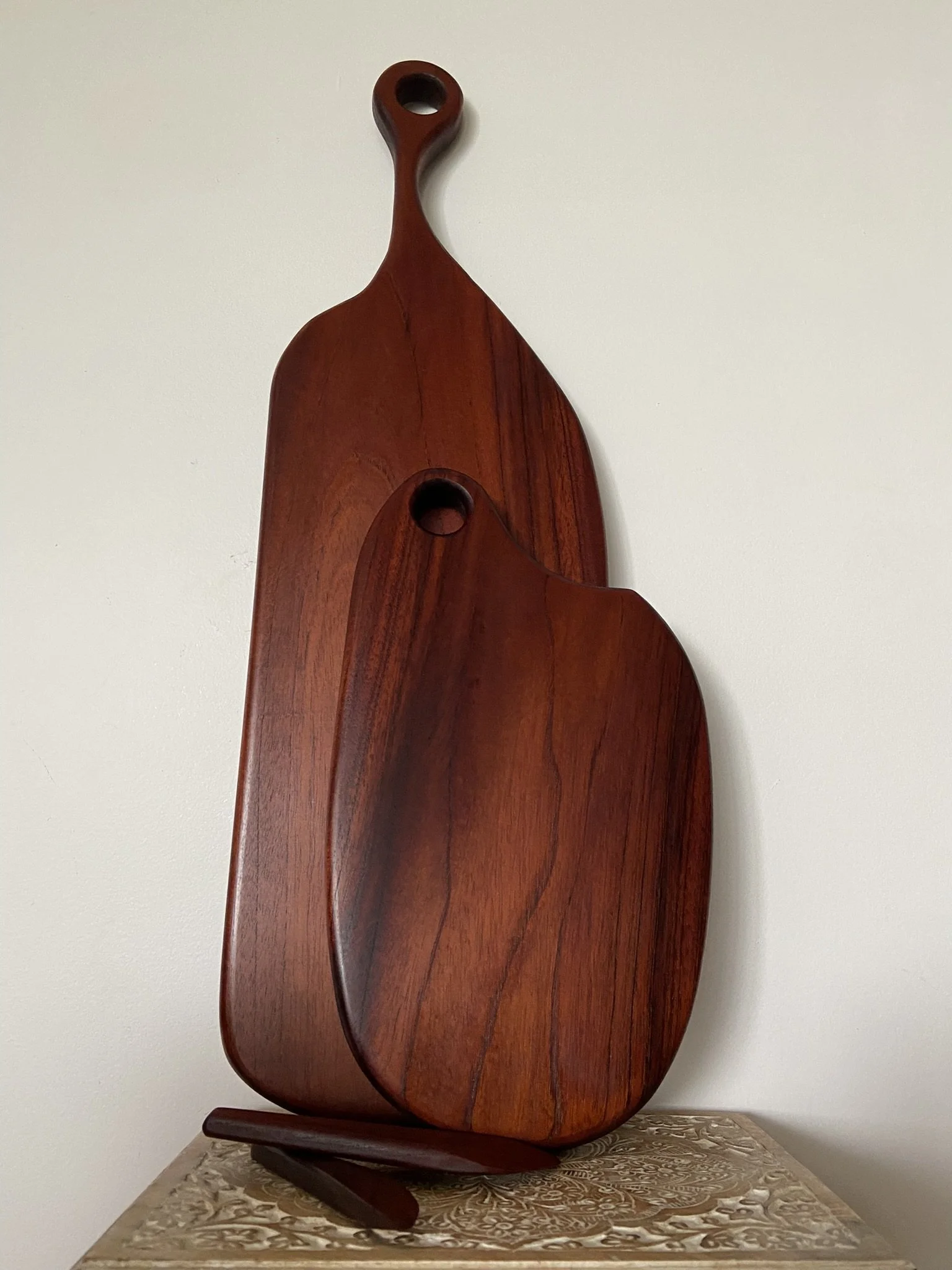 Two wooden serving platters on a textured surface against a plain wall.