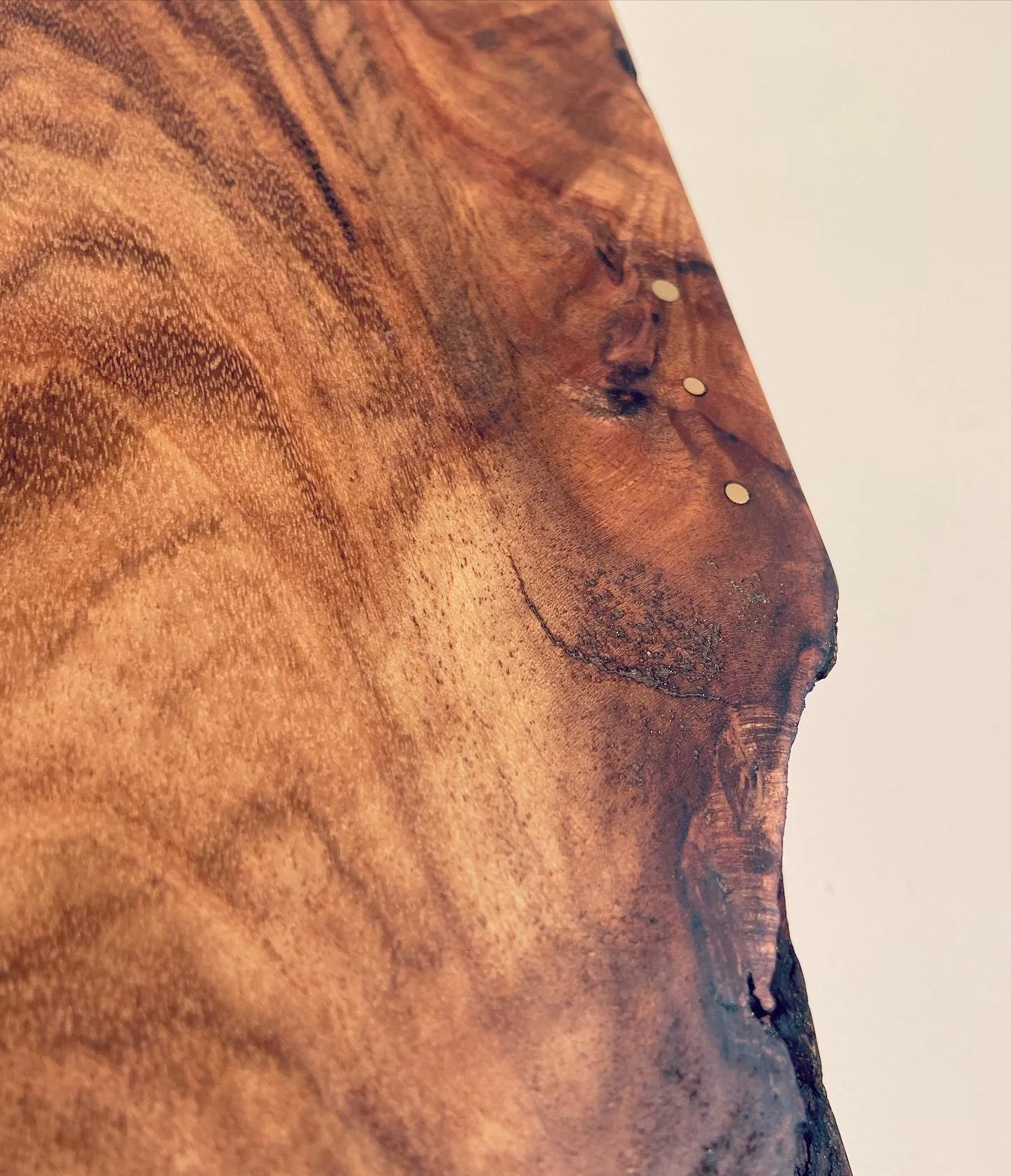 Close-up of a wooden surface showing grain patterns, knots, and natural imperfections.