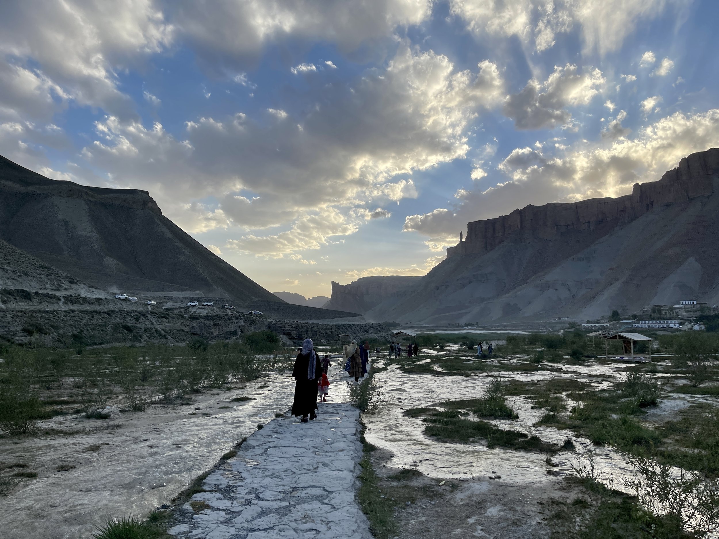   Image caption: This photograph, taken in July 2023, captures a moment just before the closure of national parks, including the renowned Band-e-Amir, to women visitors. In the image, a line of women, gracefully draped in hijabs, are seen making thei