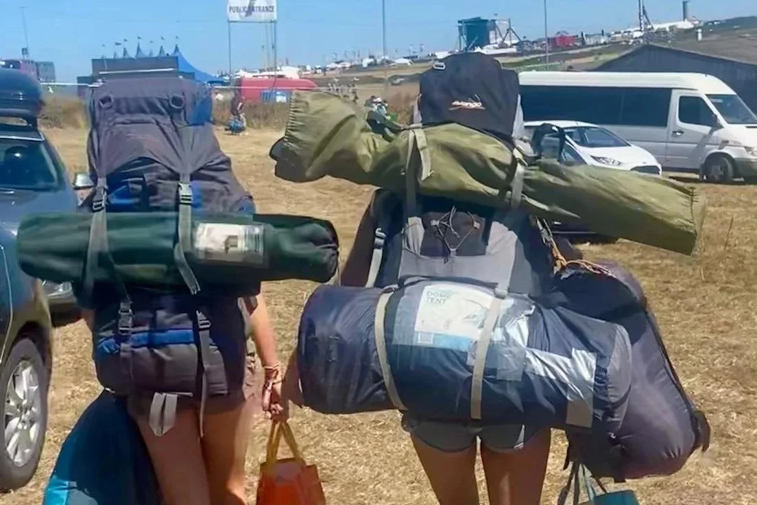 Teenagers with backpacks arriving at Boardmasters drop off point