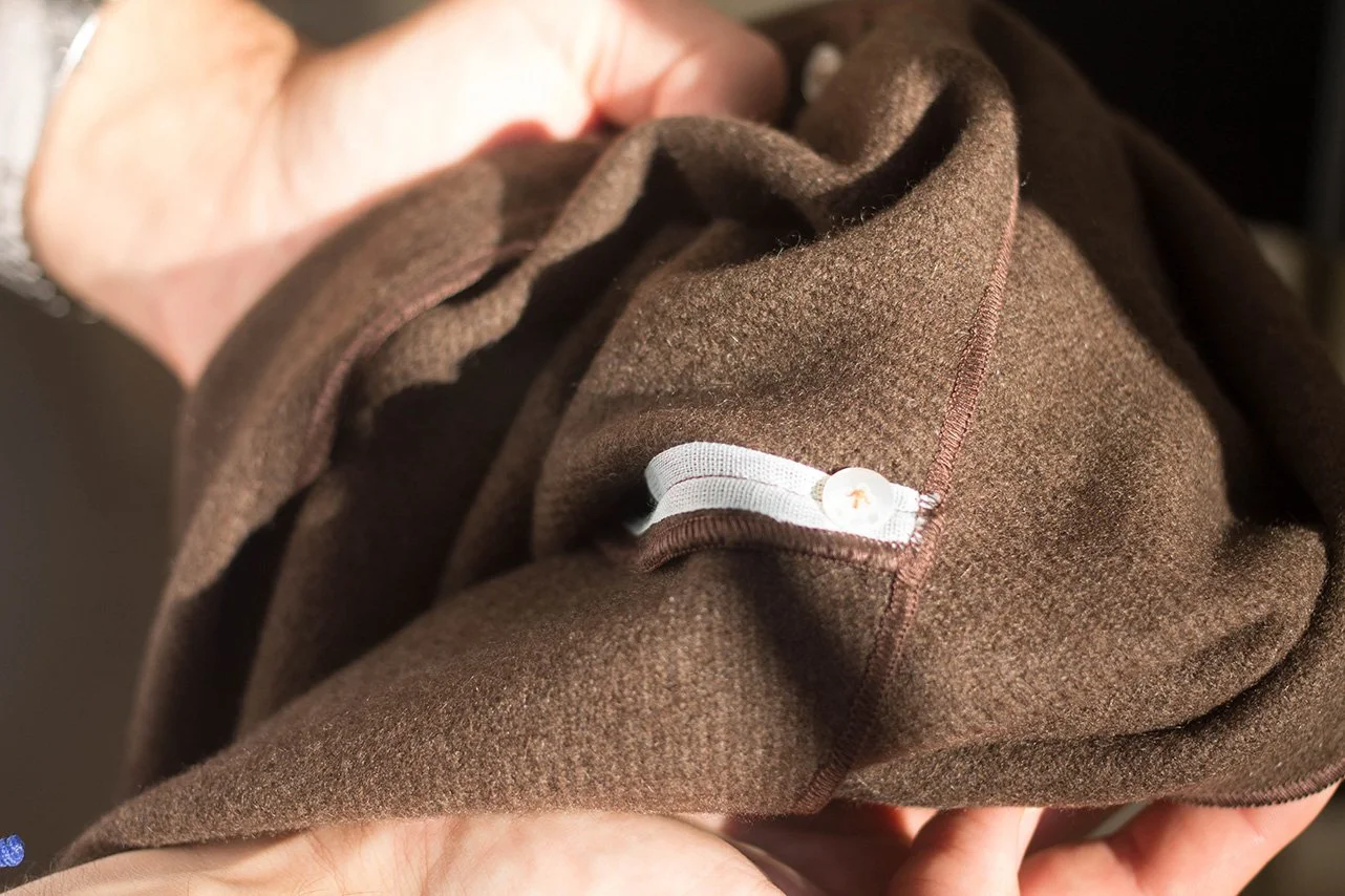 The inside of a jacket in natural (undyed) Yak wool. Details include Japanese ramie tape and mother of pearl buttons