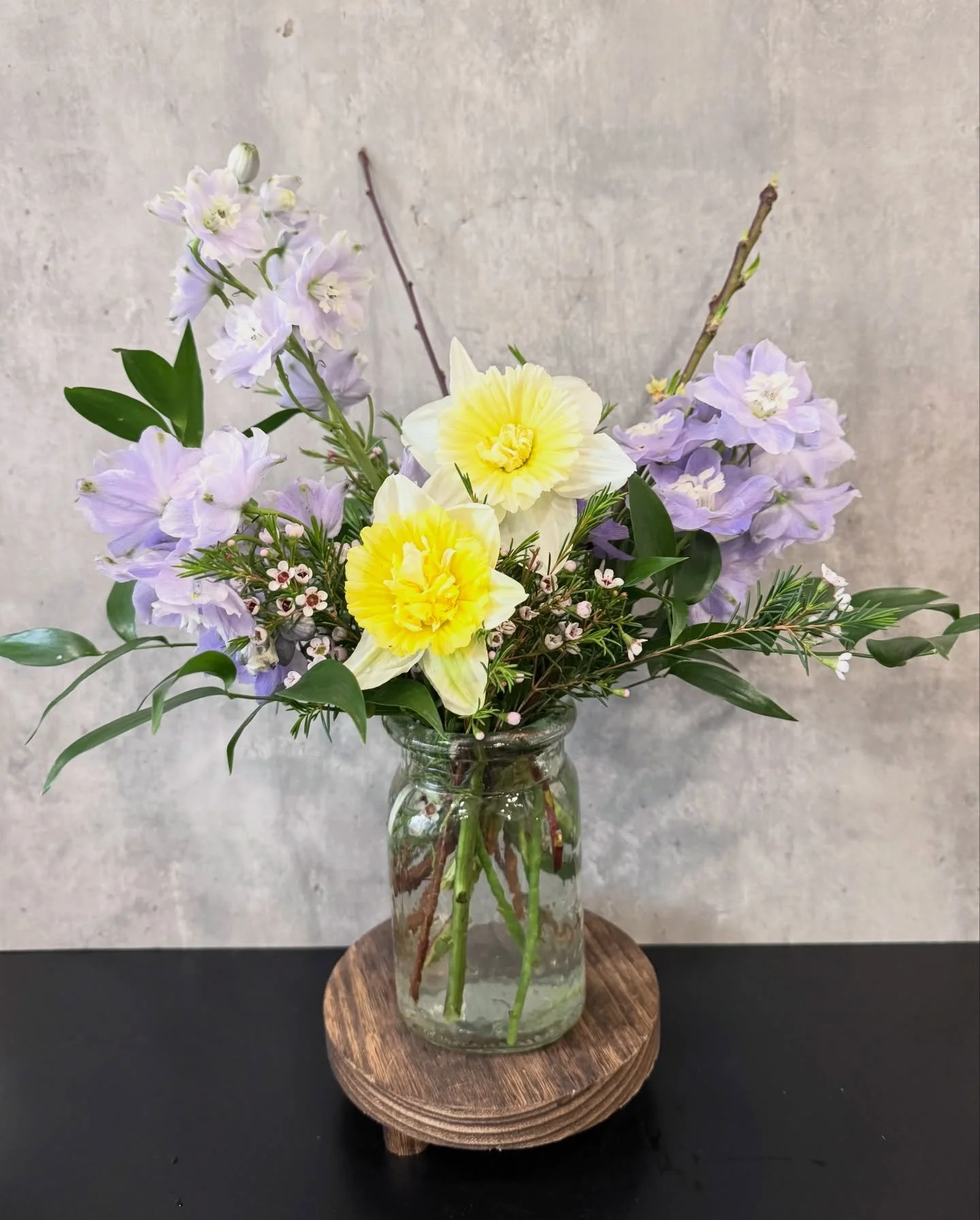Pulled the delphinium, ruscus and wax flower from a fading arrangement ➡️➡️ made a new piece by adding 2 fancy daffodils and some flowering branches.

What do you think?