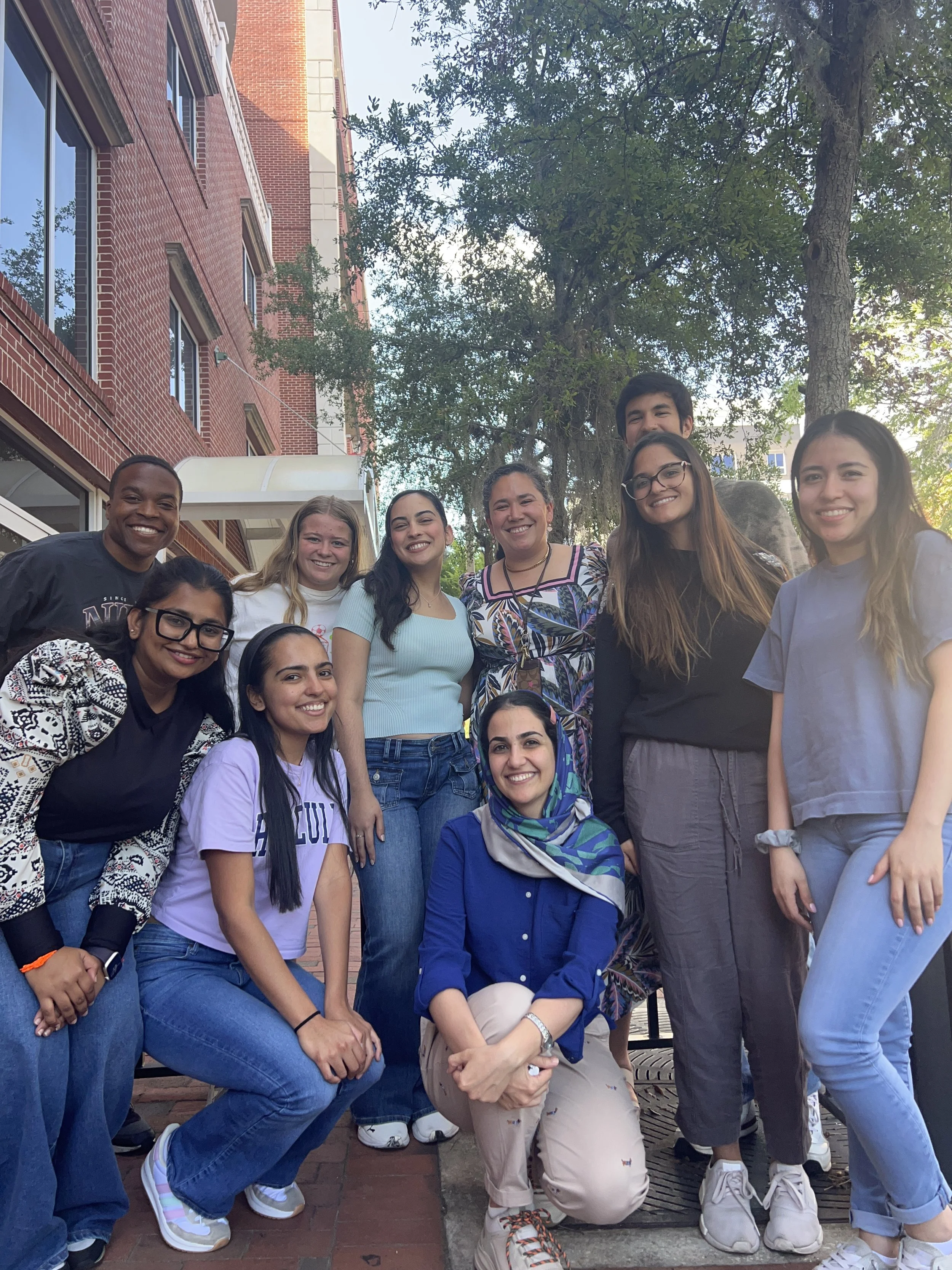 Group photo outside the lab building with team members gathered together on a sunny day.