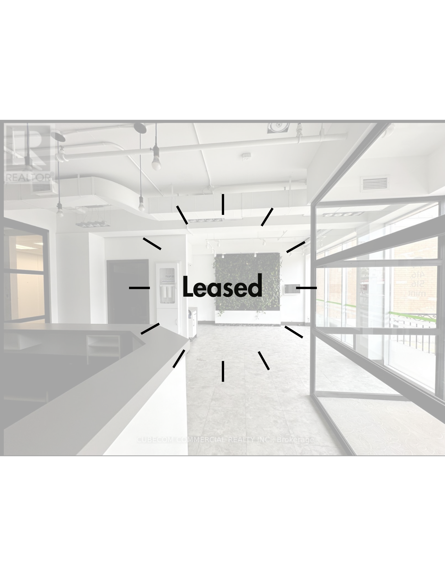 Commercial space with large windows, plants on the wall, and