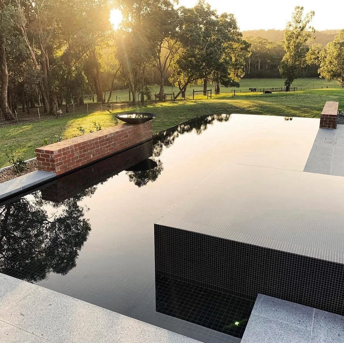 Good pool design is about balance.

This one blends into its surrounds with darker tiles and a negative edge that softens the line between garden and water.

It doesn&rsquo;t just look right, it works harder too. Dark tiles naturally hold more heat, 