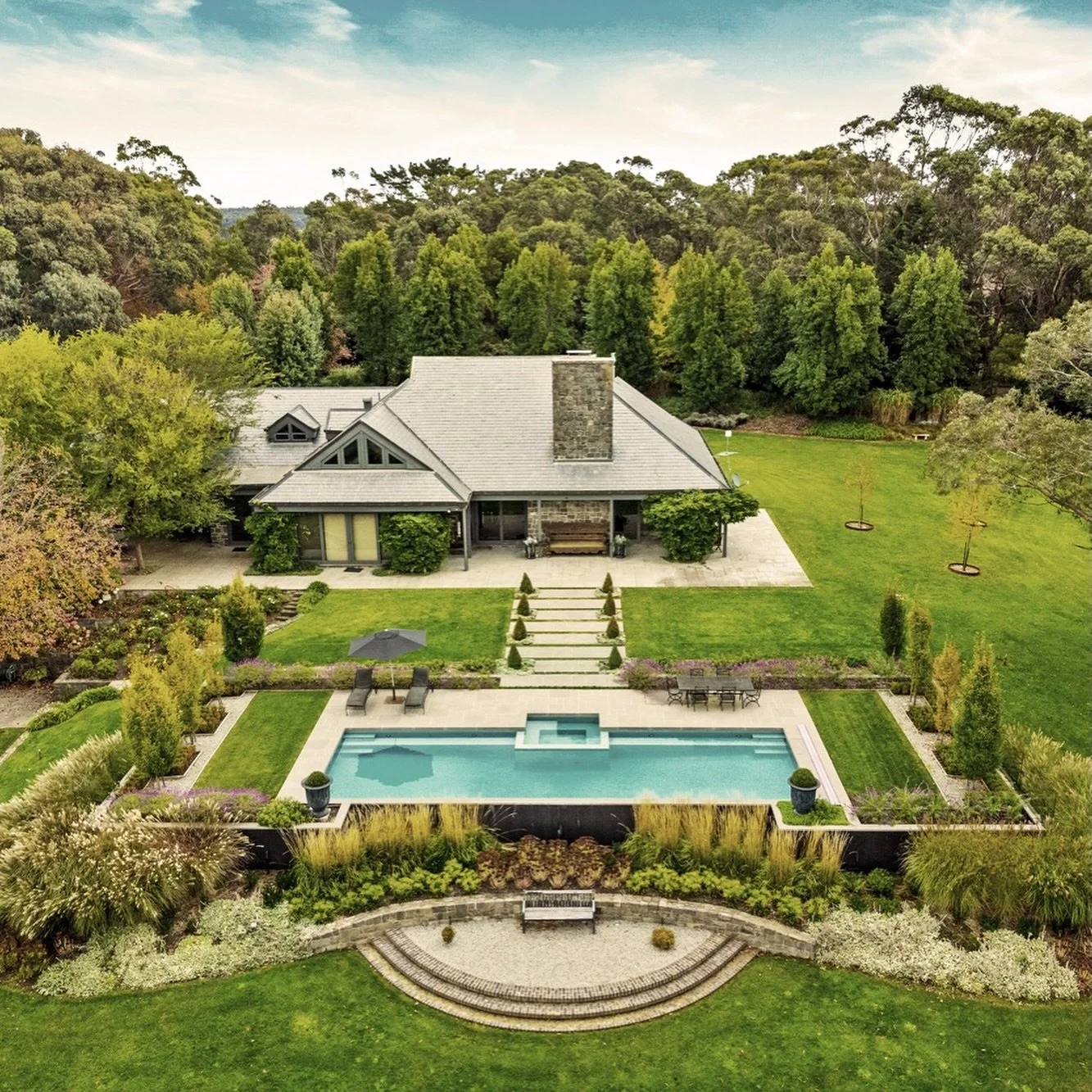 A country estate calls for a pool that can hold its own.

Positioned to take in the full width of the landscape, with levels set so the waterline runs clean through to Mount Macedon.

Planting softens the edge, but the geometry stays clear.

Design b