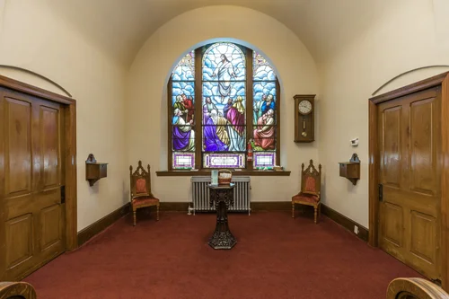 A stained glass window between two doors