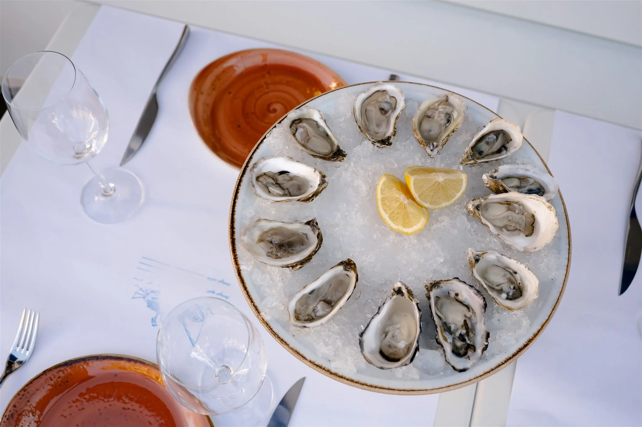 Oysters on the half shell served on ice with lemon at Scala Osteria in Napa Valley, presented as a fresh Italian seafood appetizer with simple, elegant plating.