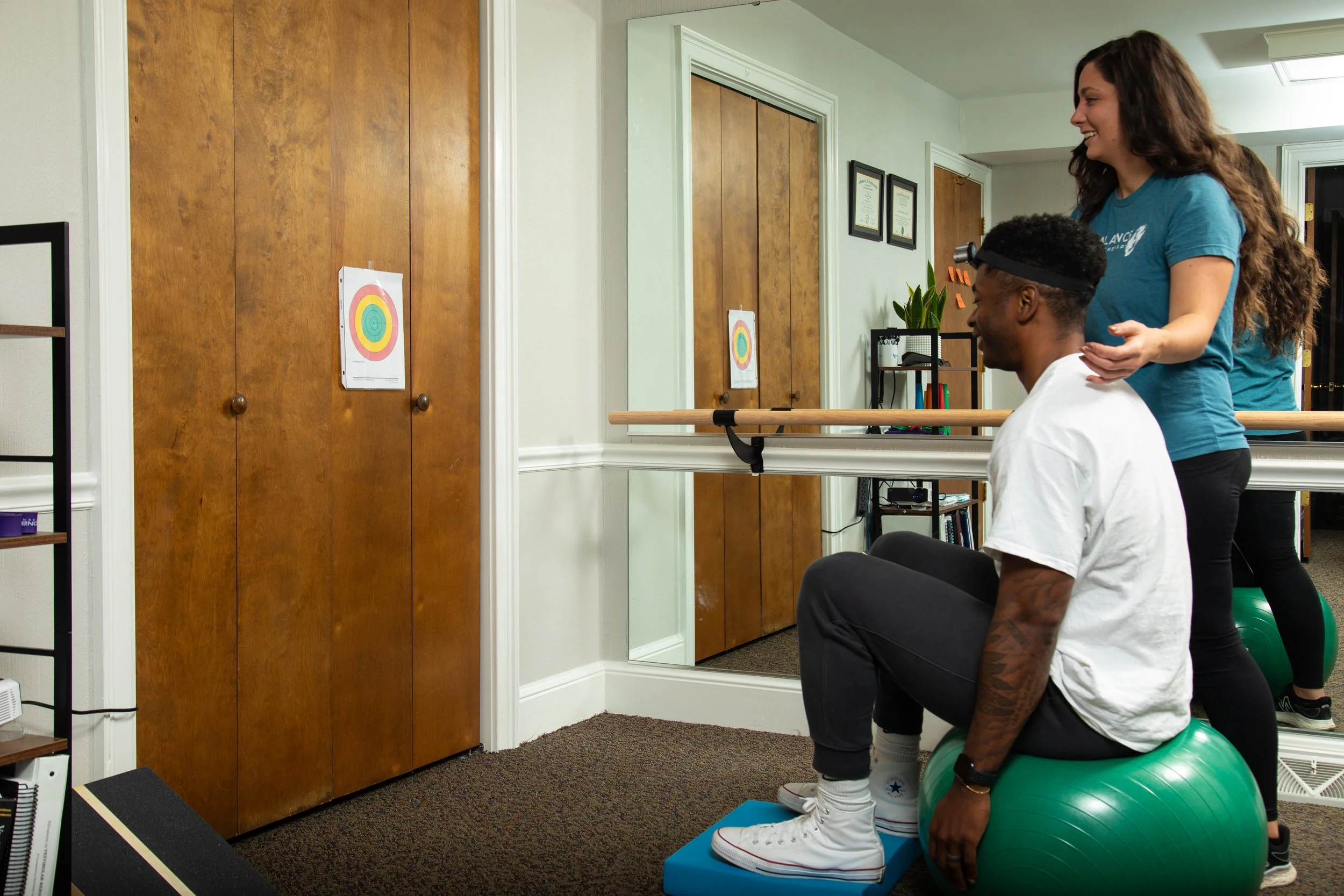 clinician performing vestibular assessment with a patient in a therapy room