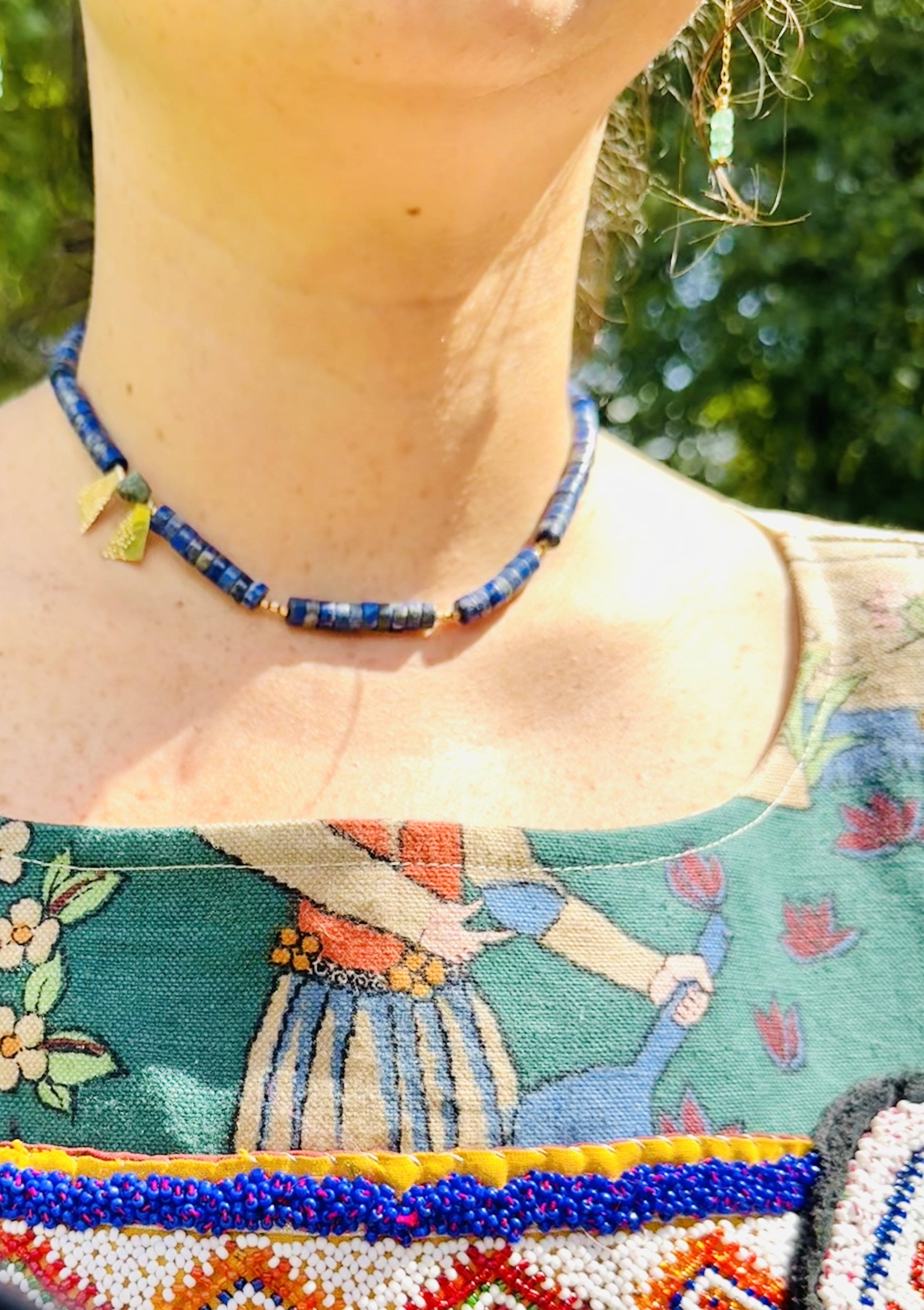 Winona Lapis necklace close-up , emerald, and gold necklace on model in Frida Shacket