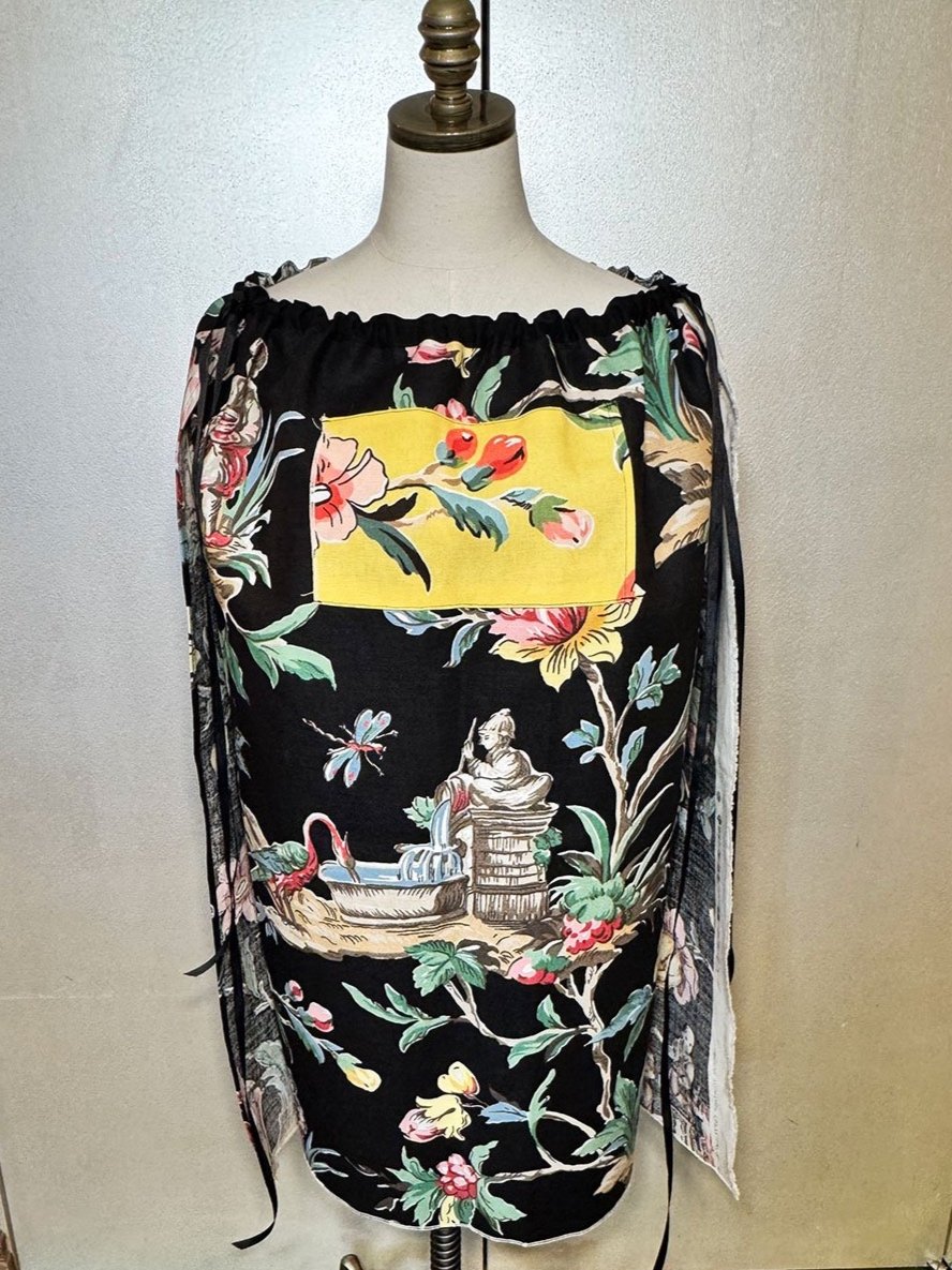 Piper skirt on mannequin shown as cape with ribbon bow accent